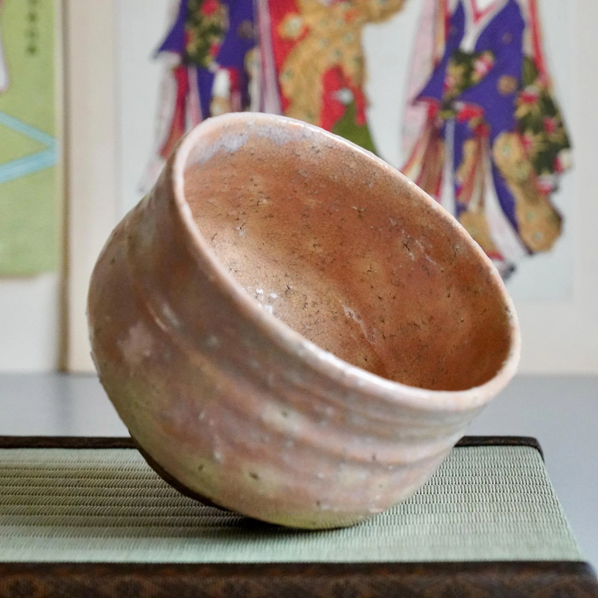 Shira-Hagi chawan Yamato Matsuroku-gama tilted showing pale interior glaze and rosy clay rim