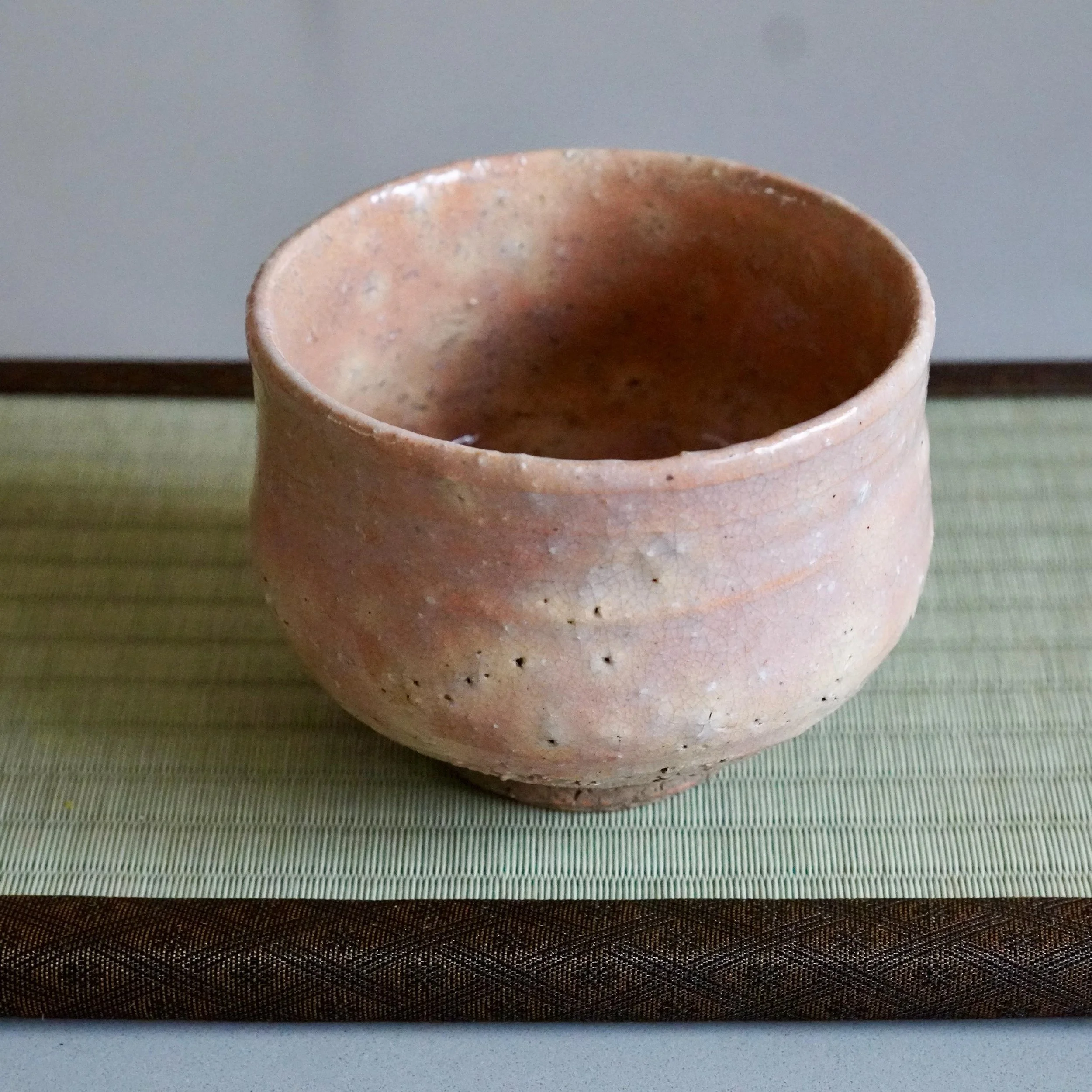 Hagi-yaki chawan Yamato Matsuroku-gama tilted showing unglazed dark clay foot ring and rough base