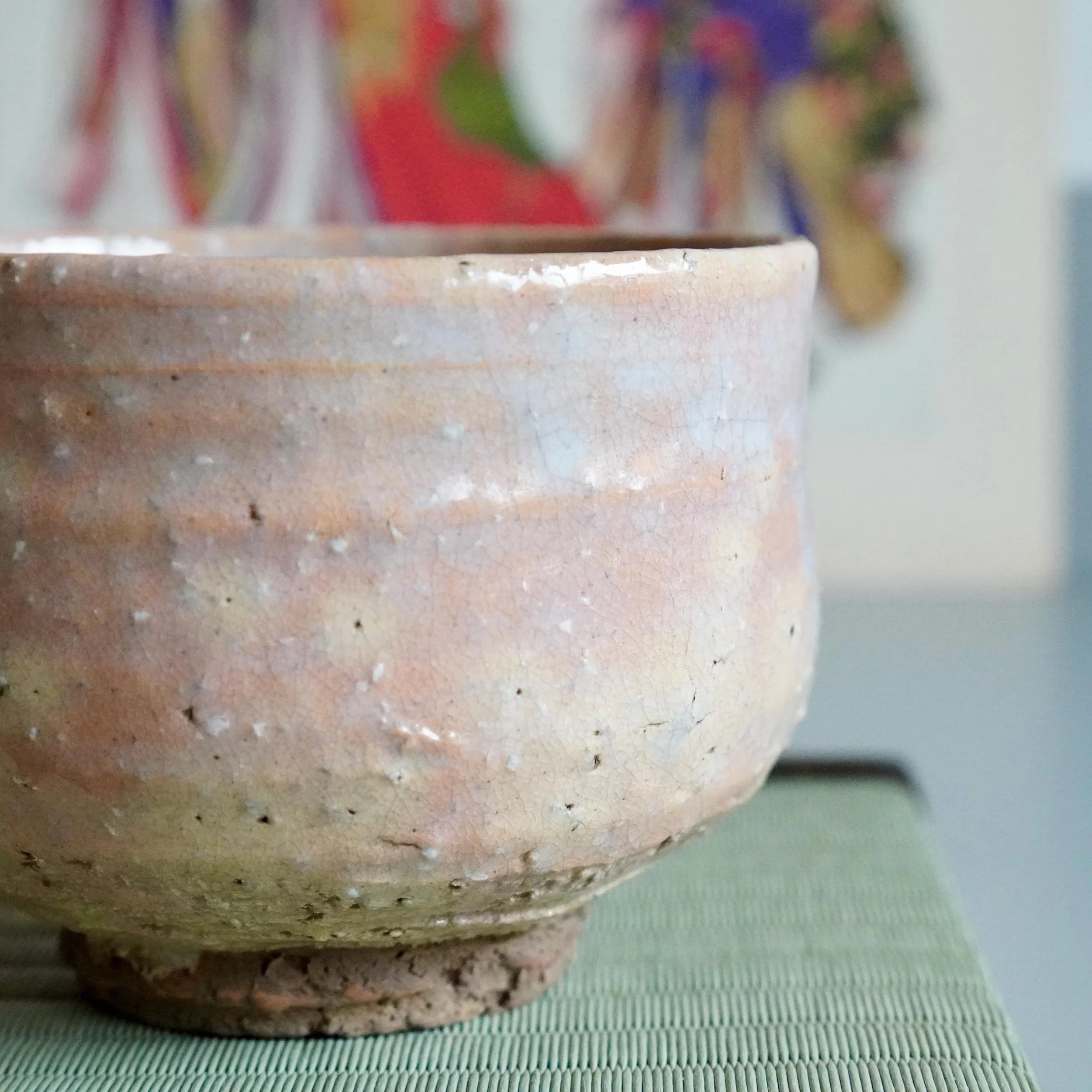 Hagi chawan Yamato Matsuroku-gama side view, glaze variation between peach and white with dark unglazed foot