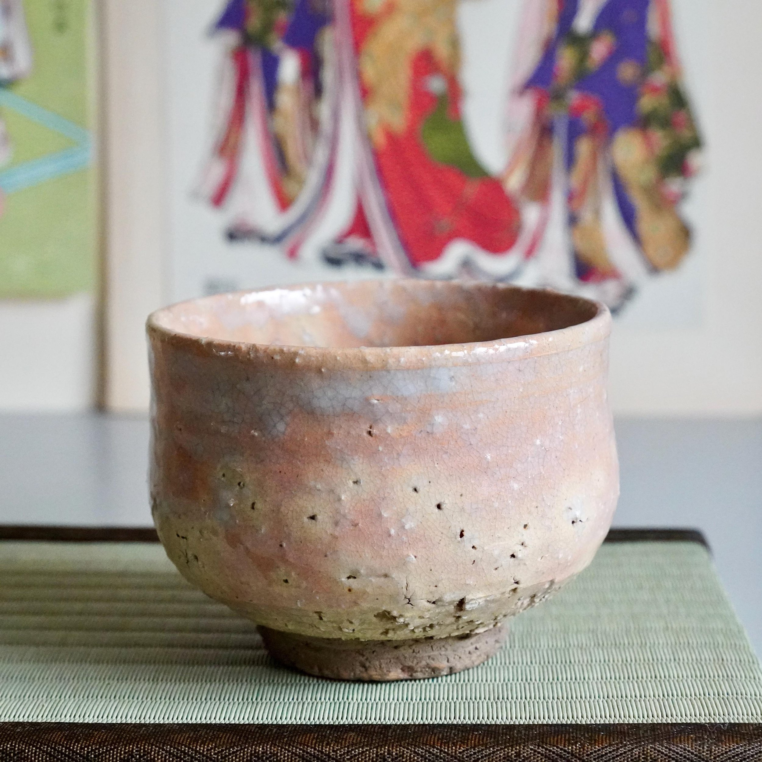 Hagi chawan Yamato Matsuroku-gama on tatami with ukiyo-e prints, showing full form and rosy shira-Hagi glaze