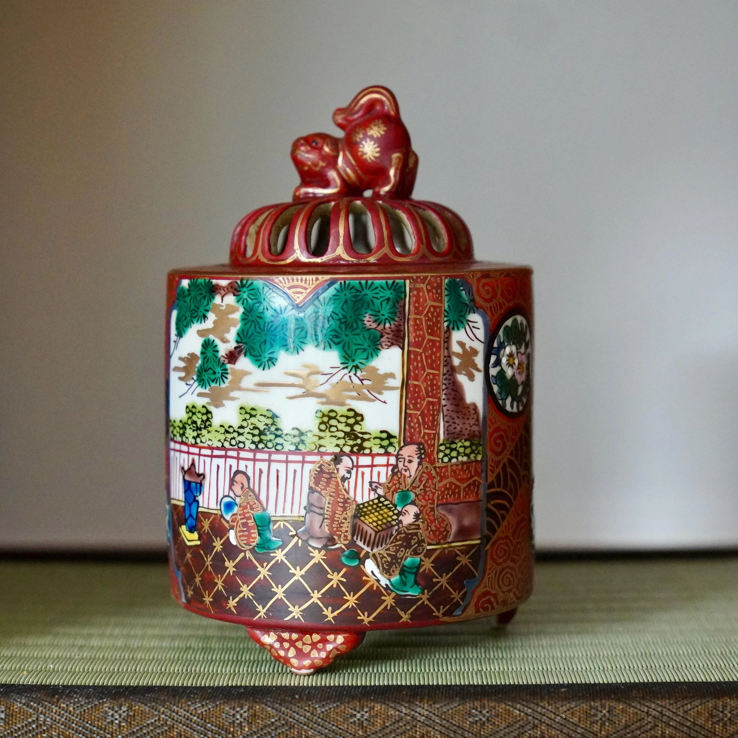 Kutani aka-e kōro incense burner overglaze enamel decoration with shishi lion-dog finial, early Shōwa period Japan, displayed on tatamimat