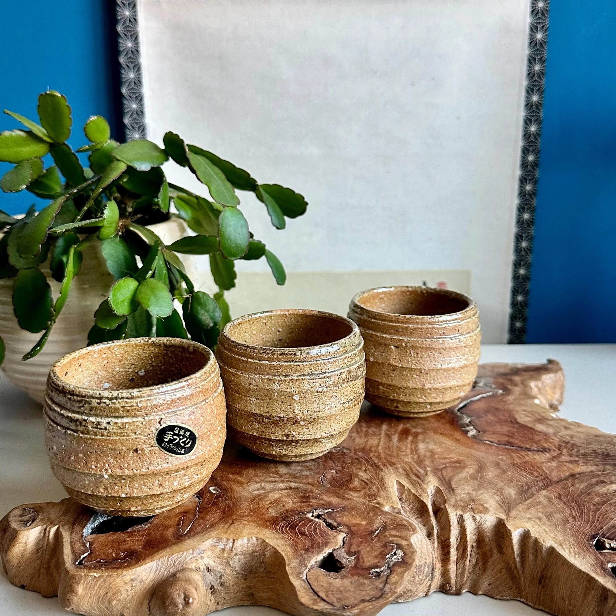 Set of three handmade Shigaraki-yaki cups on driftwood stand, Japan
