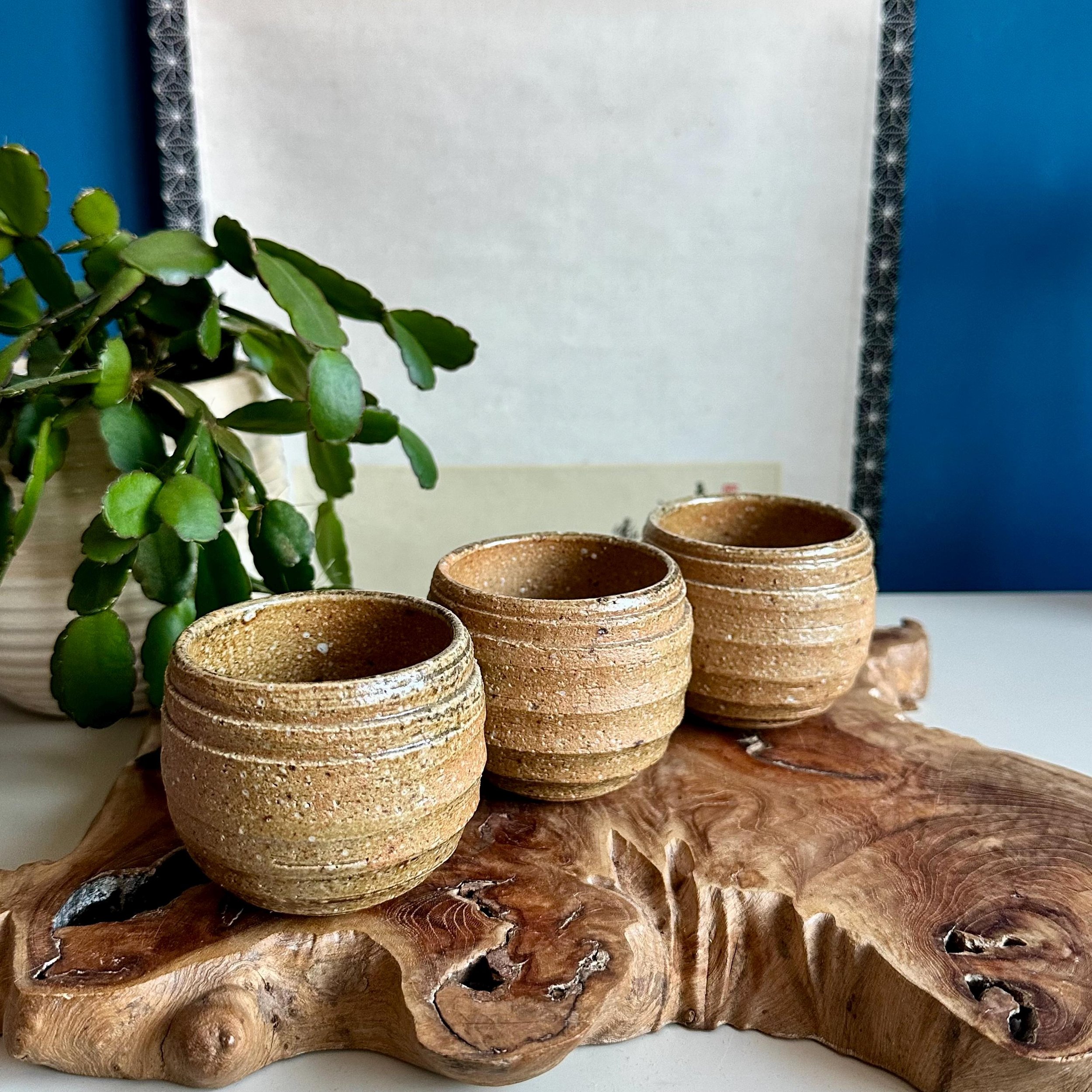 Three Shigaraki-yaki cups, Royal Yamamoto studio sticker visible on centre piece