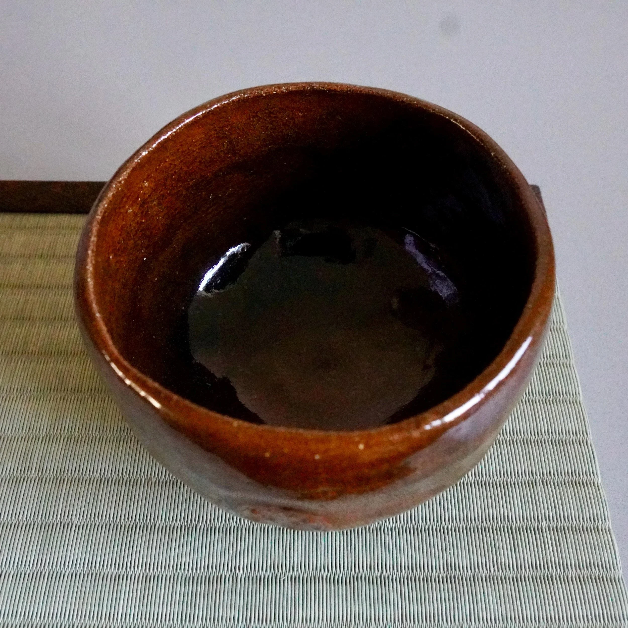 Ōbi-yaki chawan interior close-up, Kanazawa, dark pooled glaze