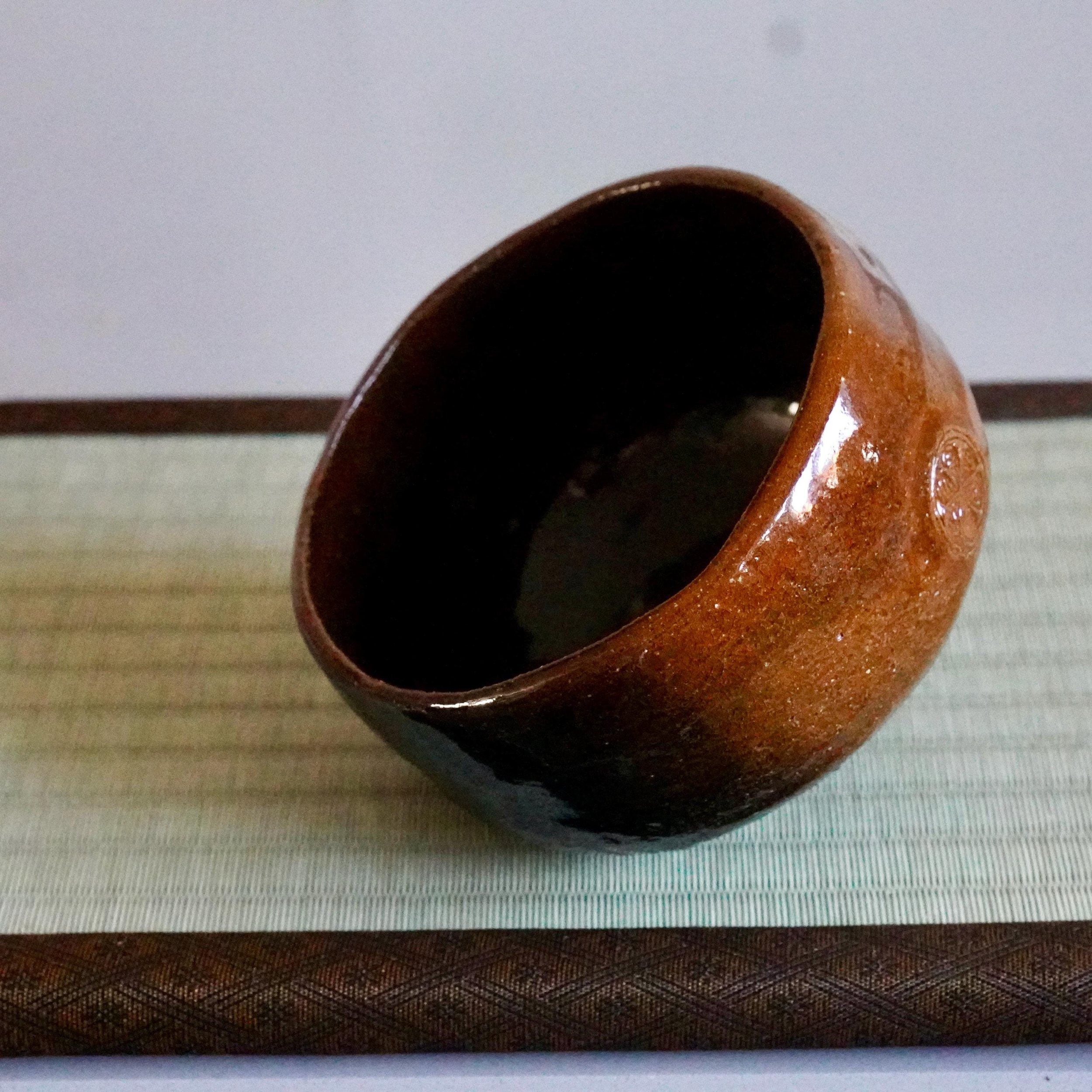 Ōbi-yaki chawan tilted view, Kanazawa, amber to black glaze shift