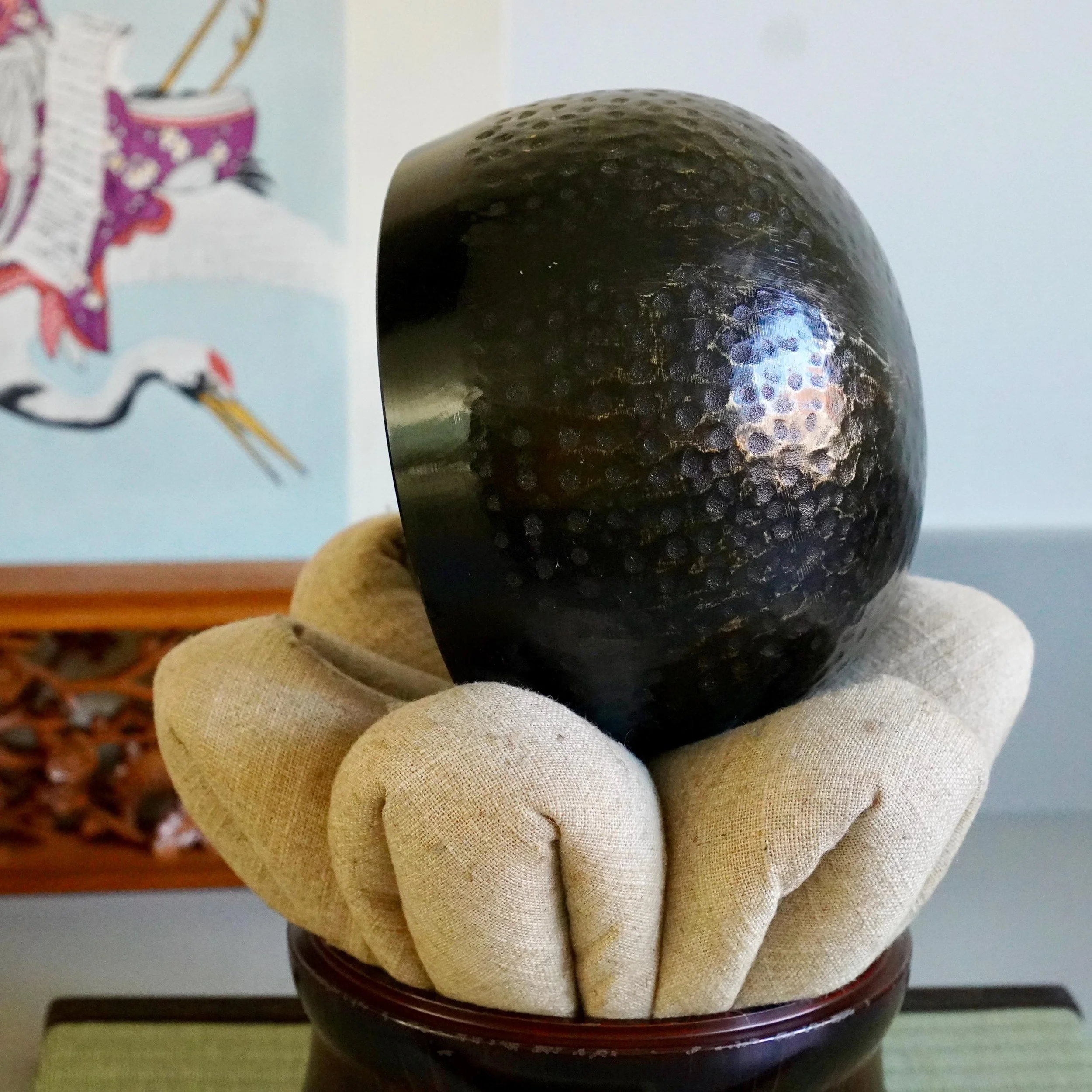 Bronze temple bell interior view resting on linen cushion