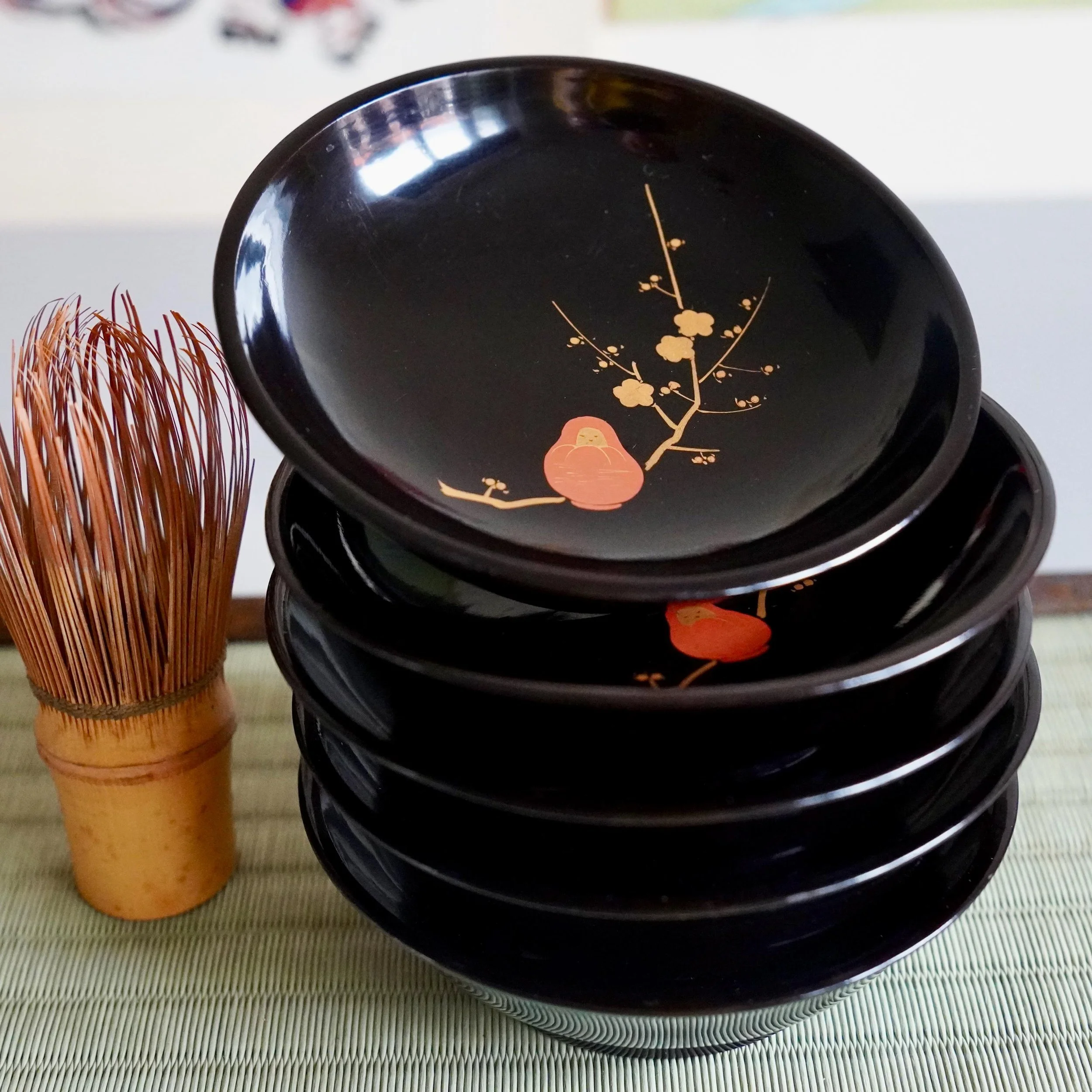 Stack of five black daruma tea ceremony urushi lacquer plates with chasen tea whisk, Shōwa period Japan
