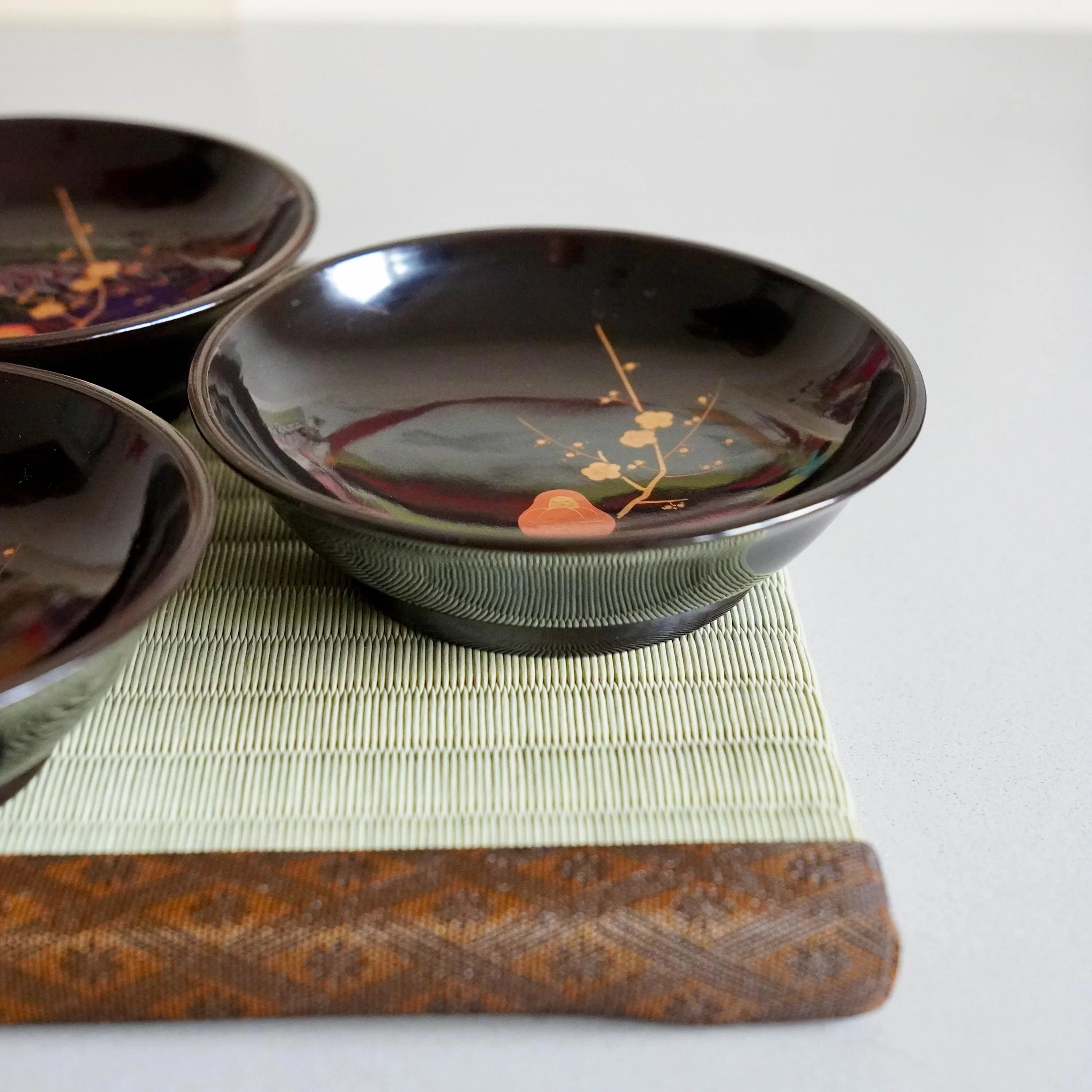 Set of black urushi plates arranged on tatami mat, Japanese tea ceremony