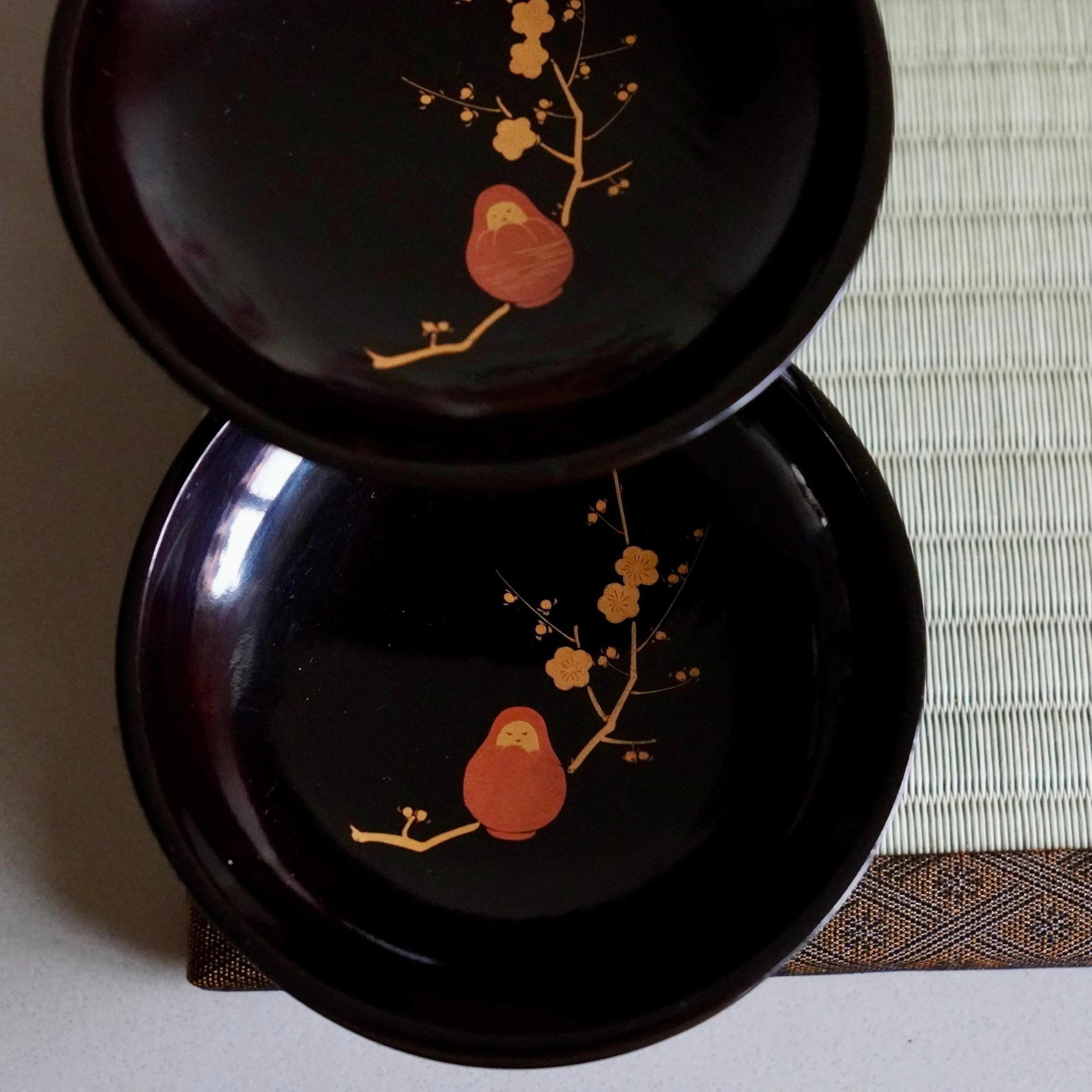 Two black urushi lacquer plates stacked, gold maki-e plum blossom detail
