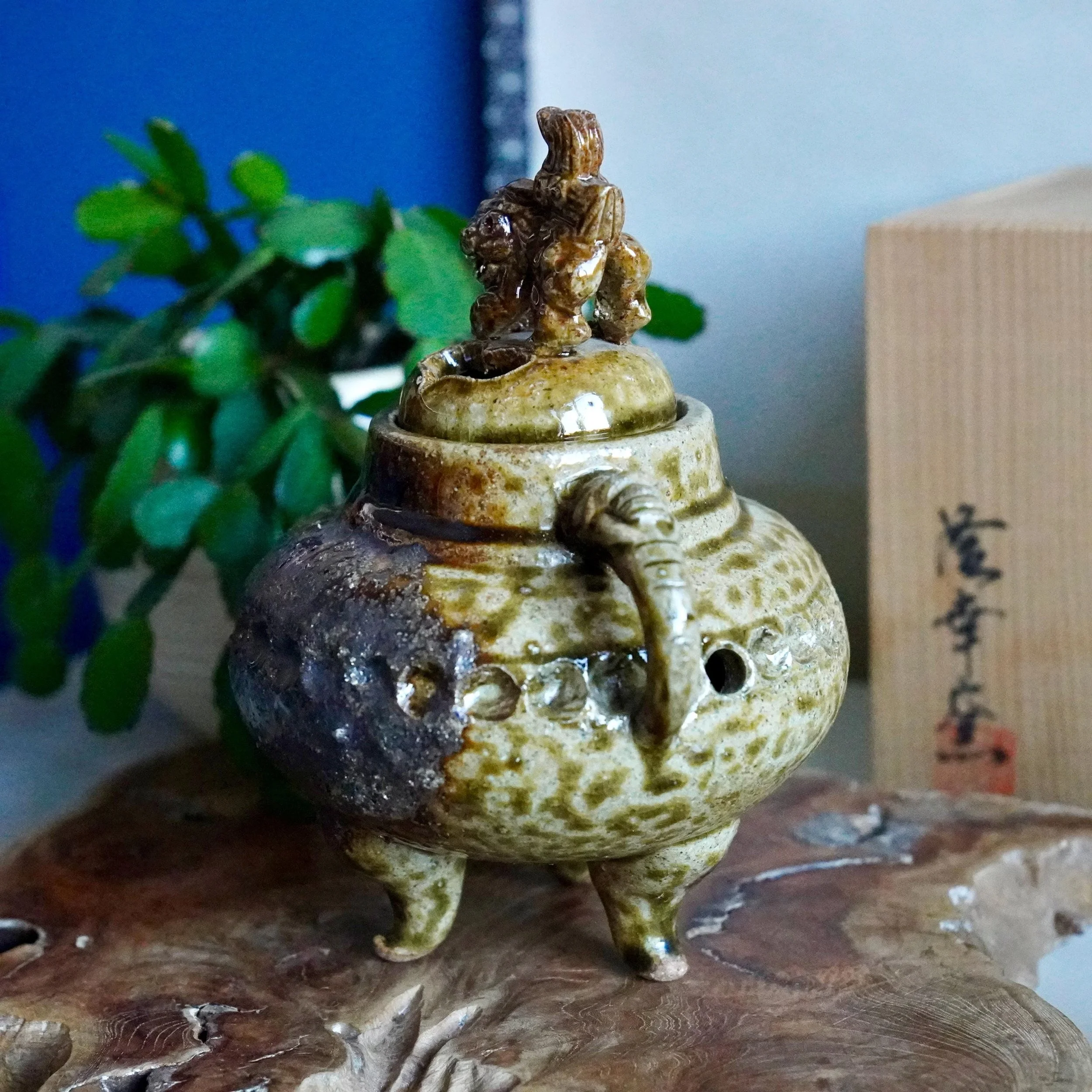 Shigaraki-yaki kōro, angled view, potted plant in background, shishi facing side