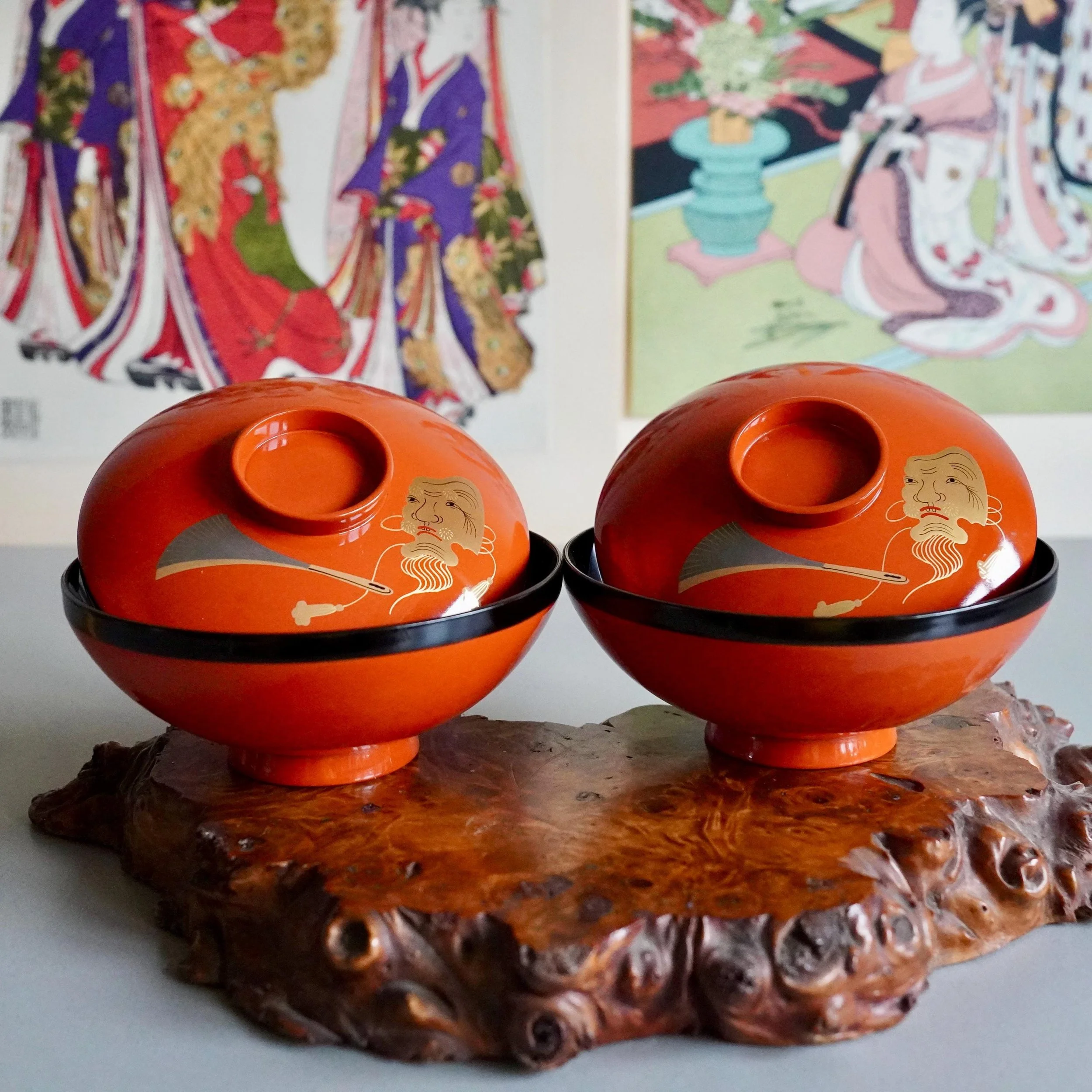 Pair of vermillion urushi lacquer owan bowls on burl wood stand, gold maki-e Okina mask