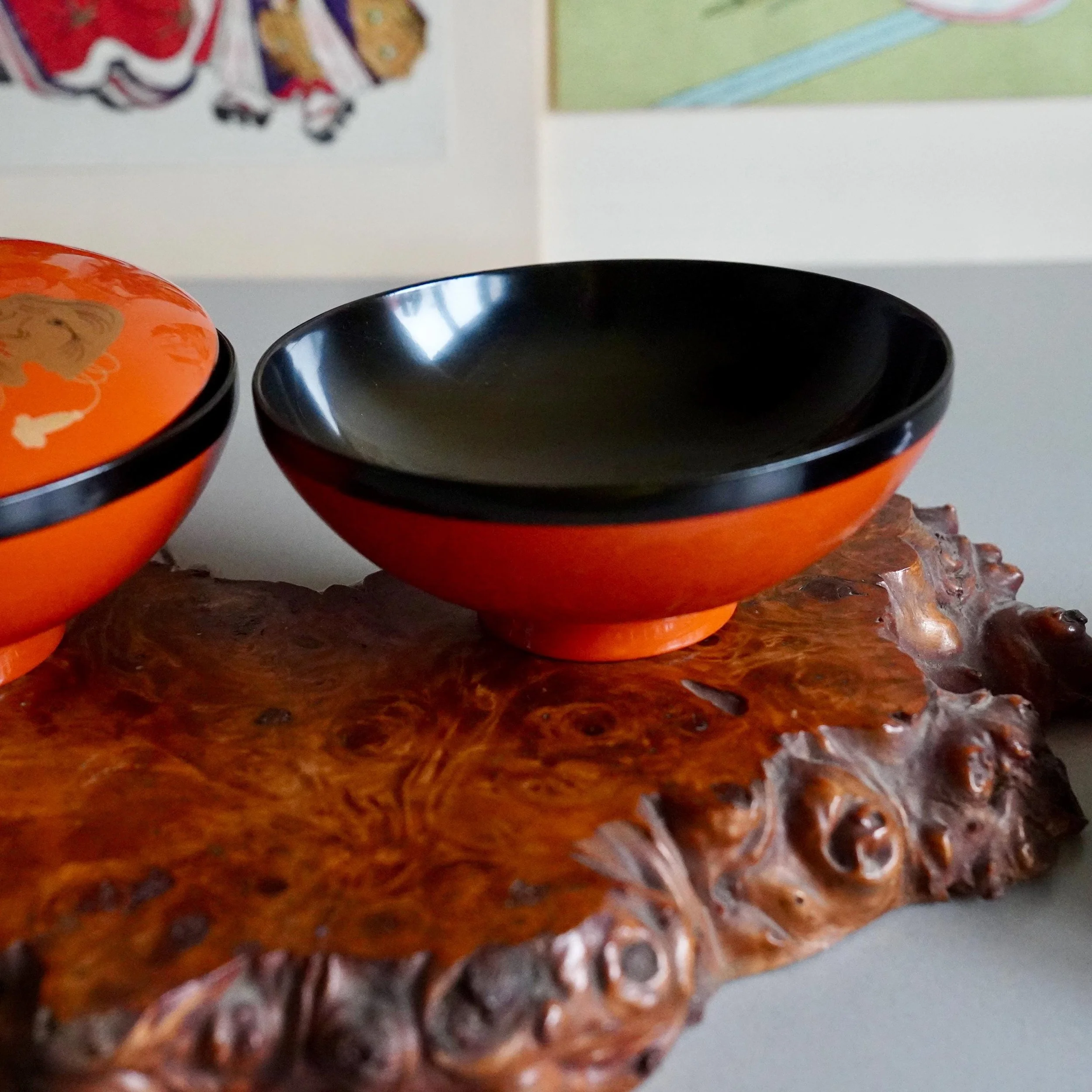 Open vermillion urushi owan bowl showing black lacquer interior on wood stand