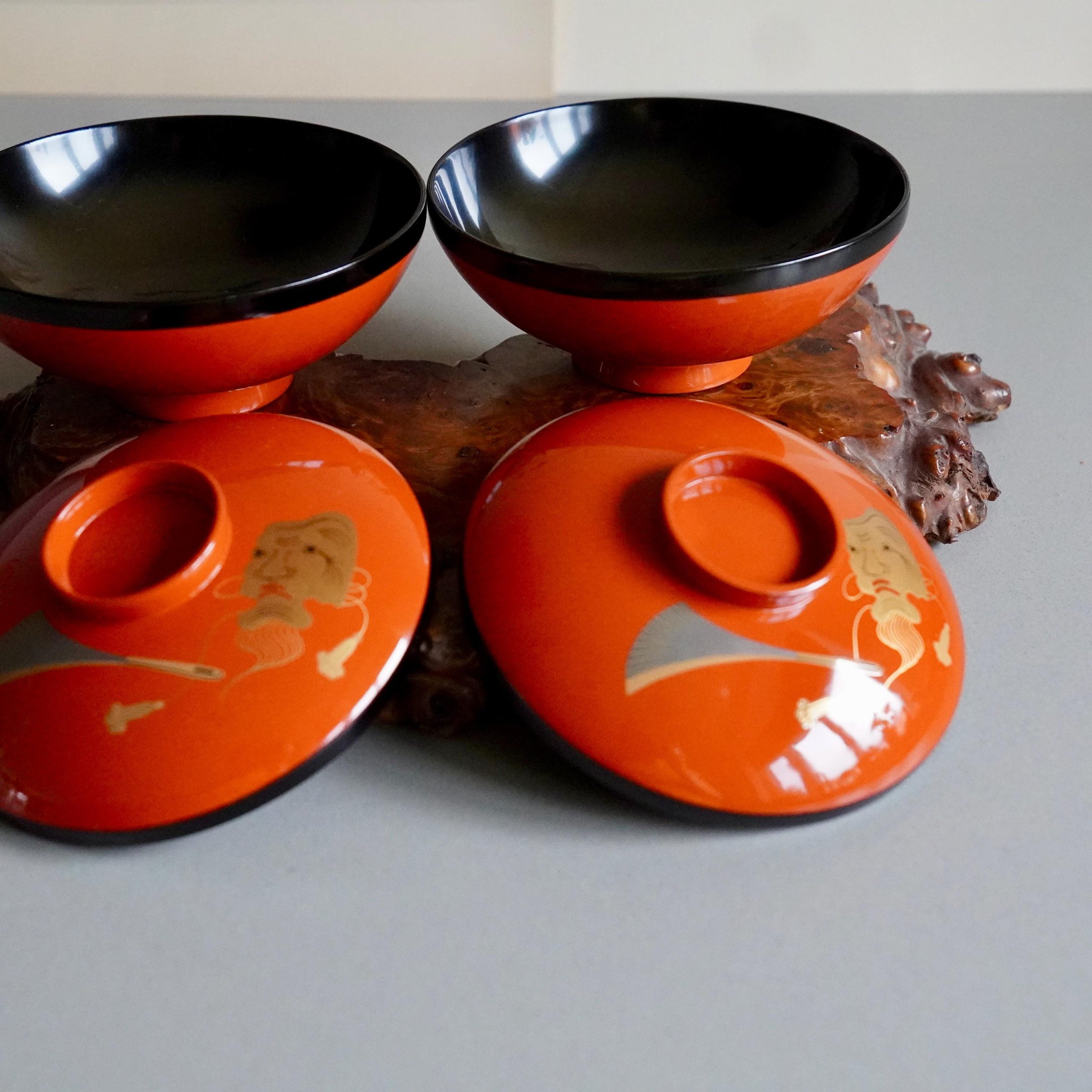 Pair of open urushi lacquer owan bowls with lids on burl wood stand