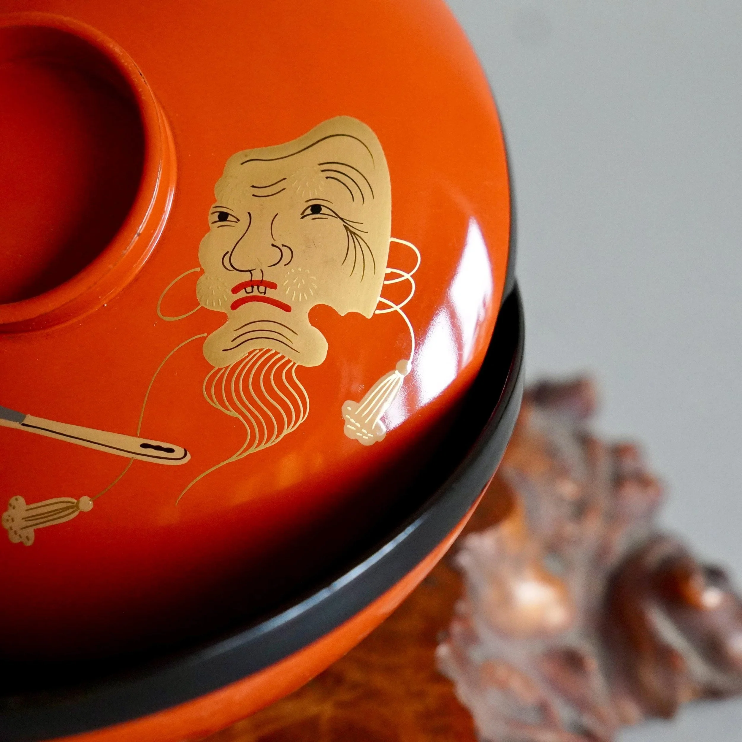 Close up of black lacquer noh mask gold maki-e of urushi owan bowl