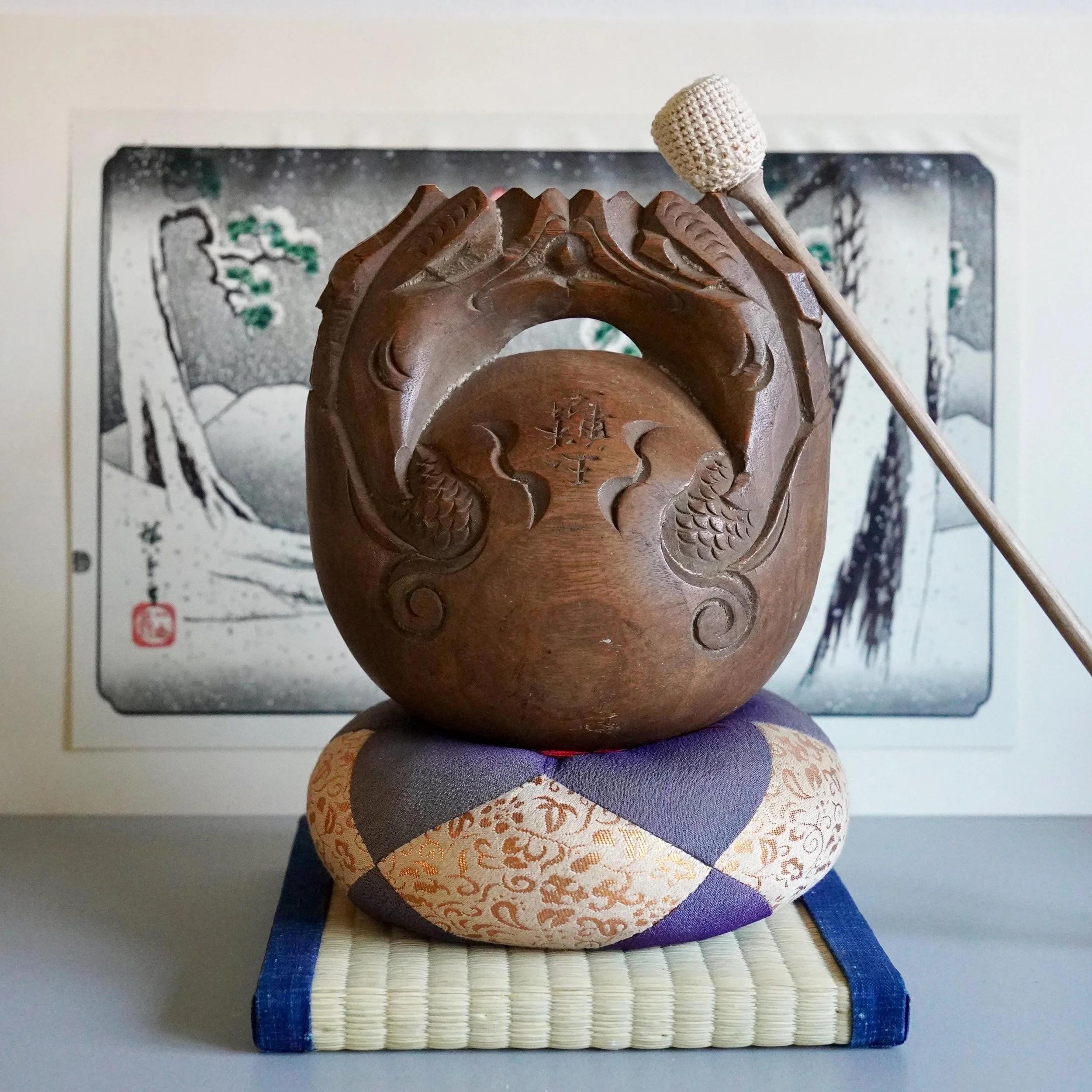 Large wooden ryurin-o dragon fish mokugyo Gyokurin carved temple percussion instrument on pillow with striker and ukiyoe on background, late Meiji to early Shōwa period Japan