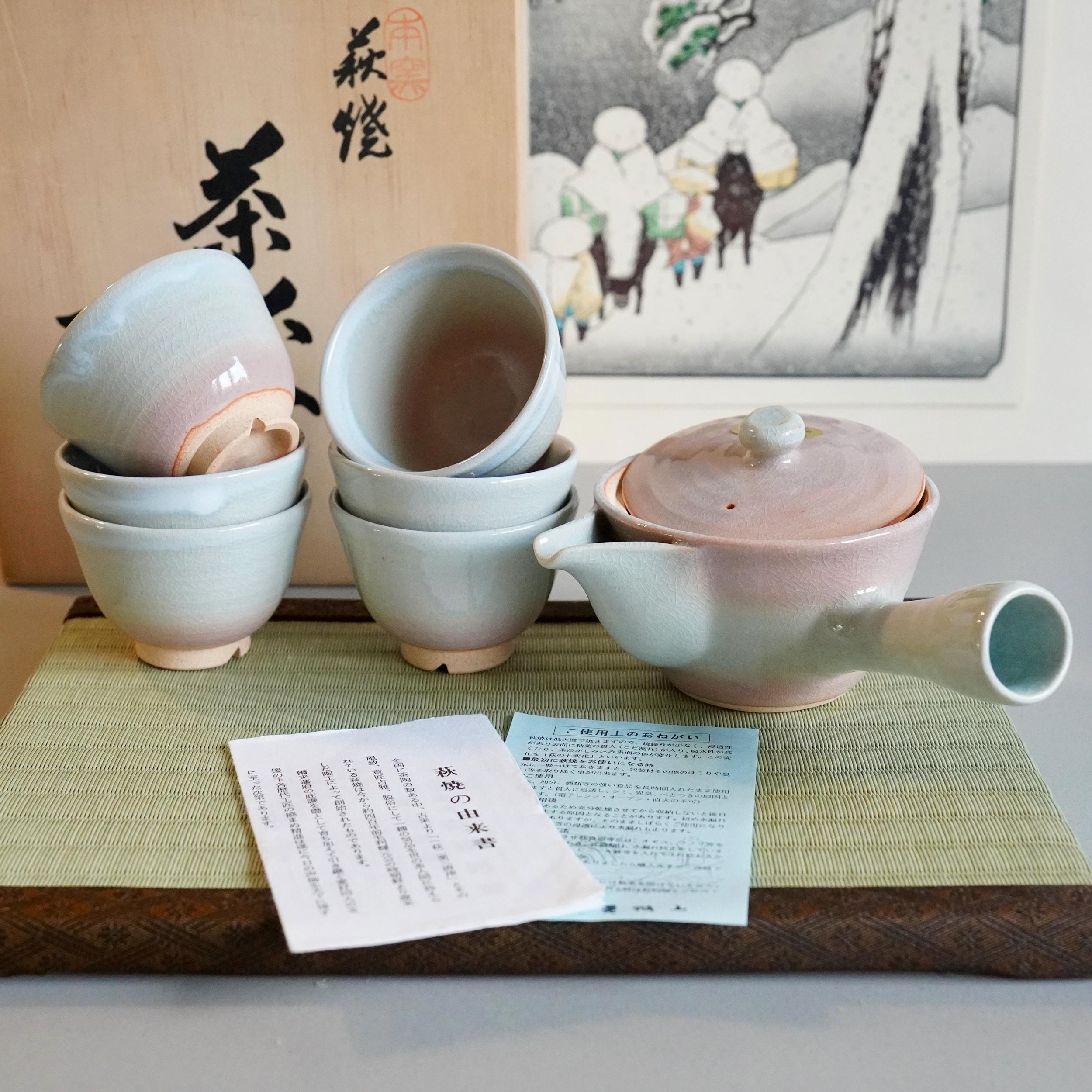 Hagi-yaki sencha tea set Hirose Tanga Nanshu Tenpōzan kiln kyusu and six cups with original tomobako, late Shōwa period Japan, displayed with shiori on tatami mat with ukiyoe print in background