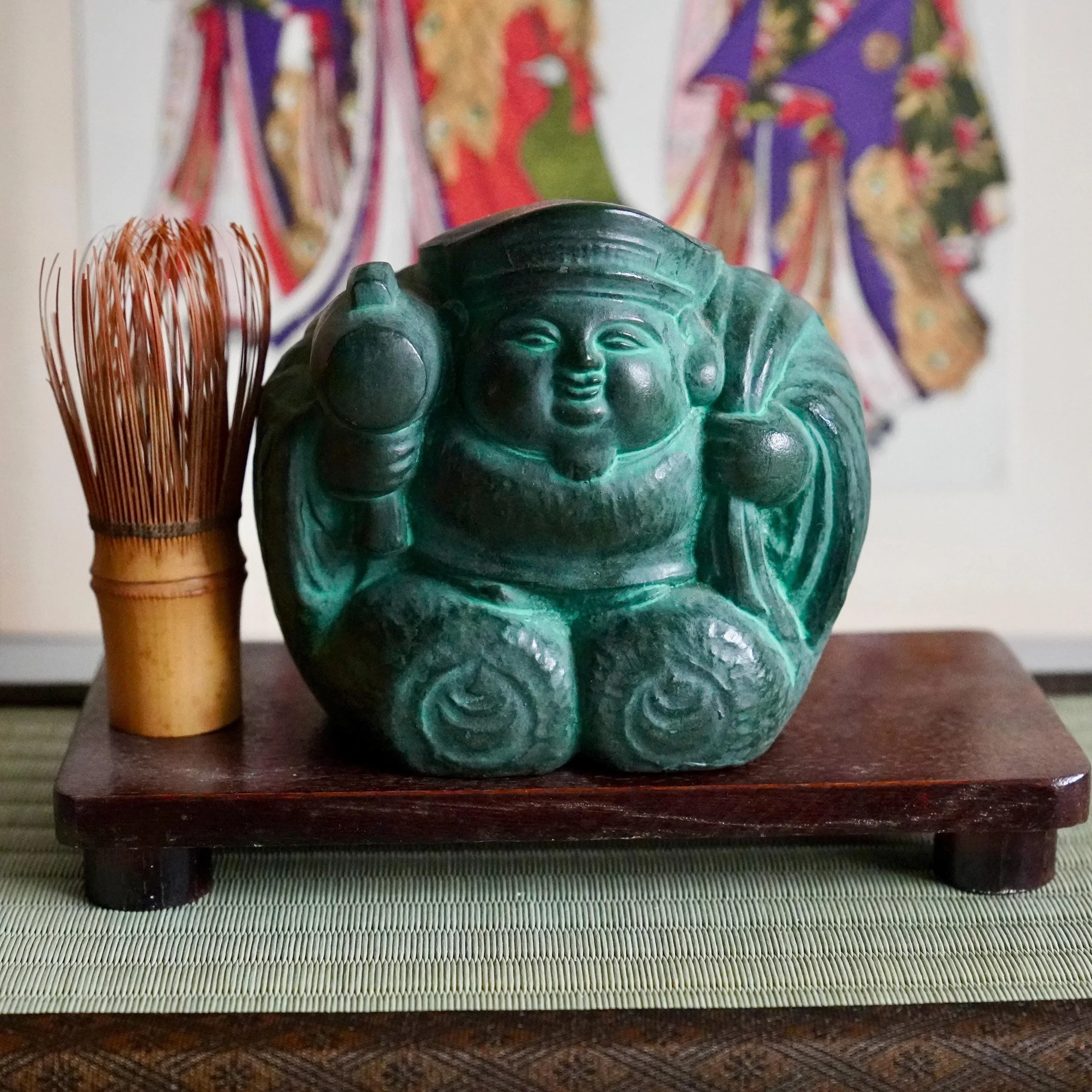 Bronze Daikokuten okimono signed Shuho Showa Japan, Seven Lucky Gods deity of wealth deep green patina, displayed on tatami mat, ukiyoe print background, with chasen