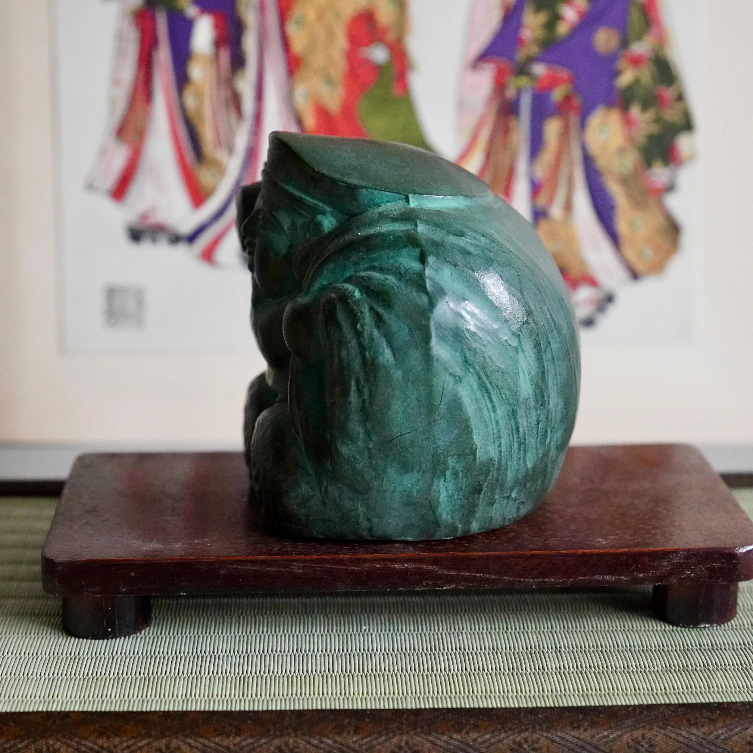 left side view Japanese bronze Daikokuten okimono showing seated posture on rice bales, treasure sack and robe folds, green aged patina, signed Shuho Showa period