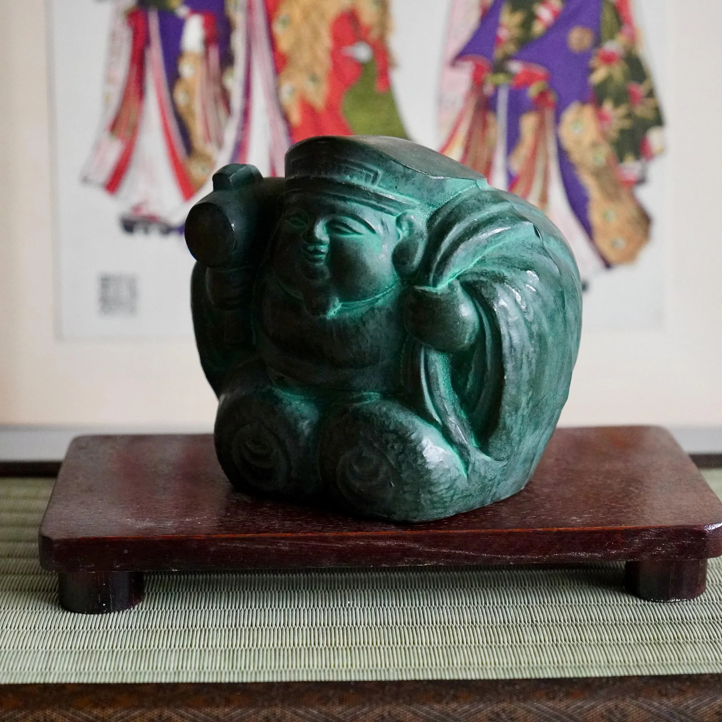 Three-quarter right angle bronze Daikokuten Japan Seven Lucky Gods smiling face and mallet visible, green bronze patina okimono signed 秀峰作, late Showa ca. 1960