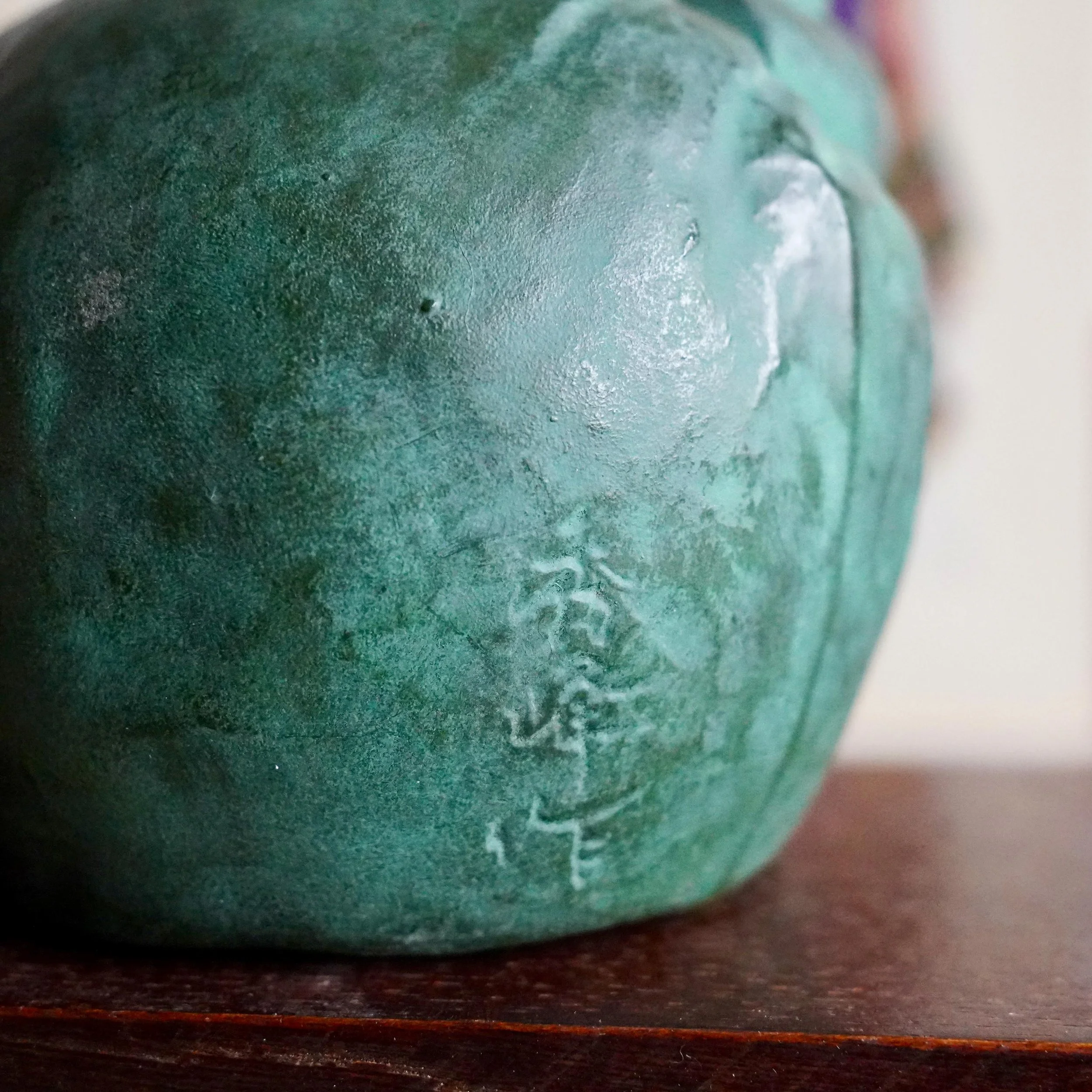 Reverse of Japanese bronze Daikokuten okimono showing signature 秀峰作 Shuho cast into the bronze, aged green patina, late Showa period Japan ca. 1960