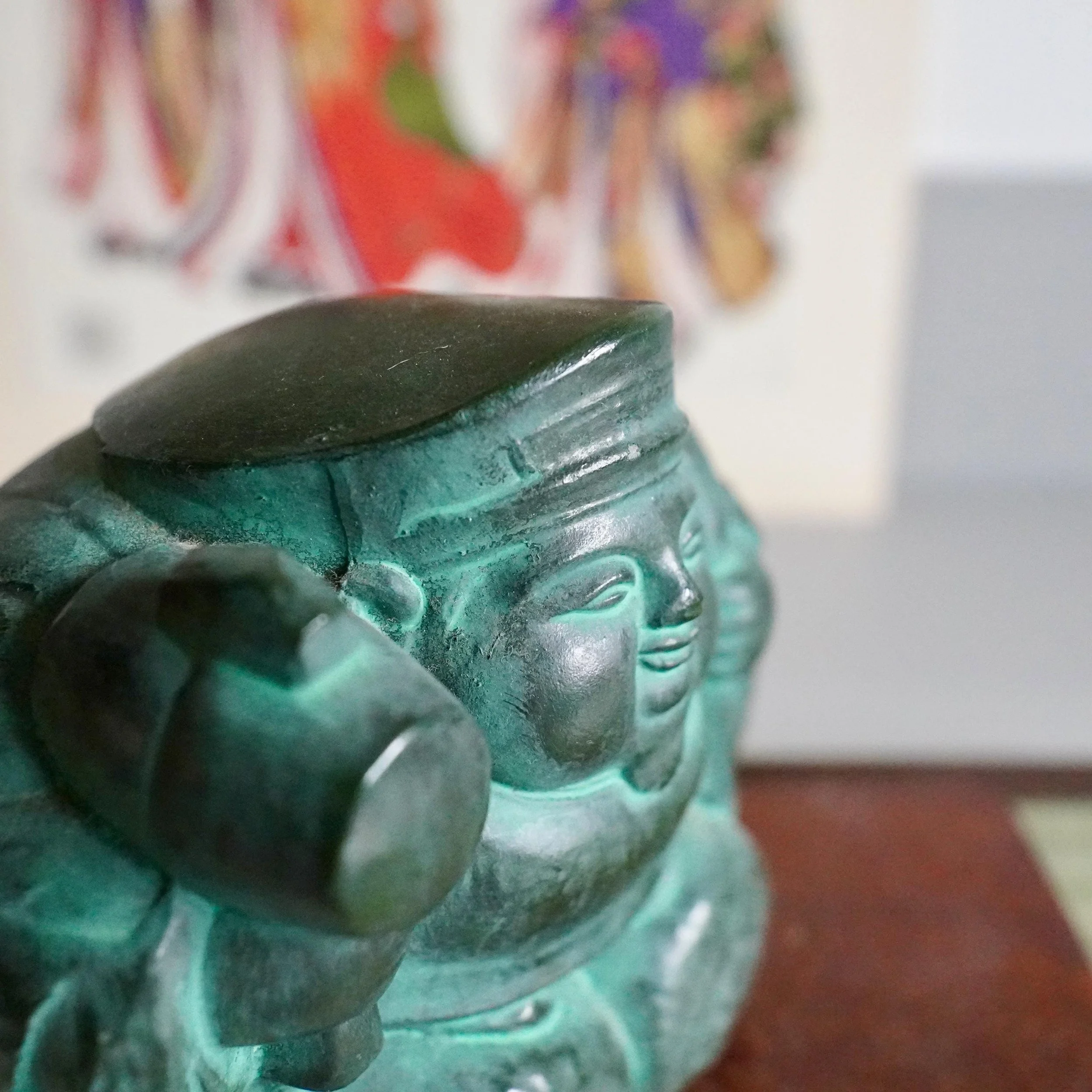 Close-up face of Japanese bronze Daikokuten deity of wealth with broad smile, flat cap and mallet raised, deep green bronze patina, signed Shuho Seven Lucky Gods Showa period