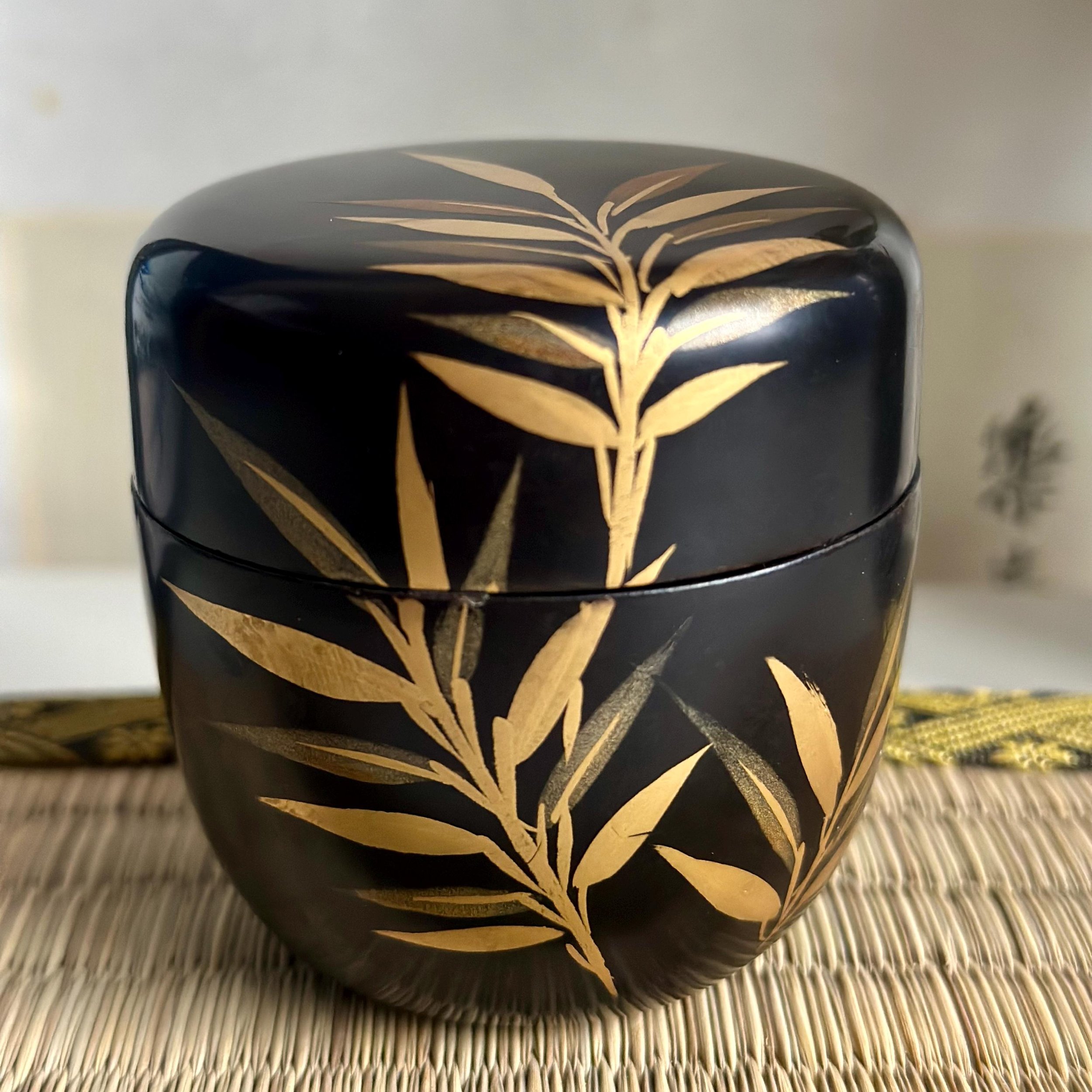 Urushi lacquerware natsume black with maki-e gold botanical decoration on wood, displayed on tatamimat, early Shōwa period Japan