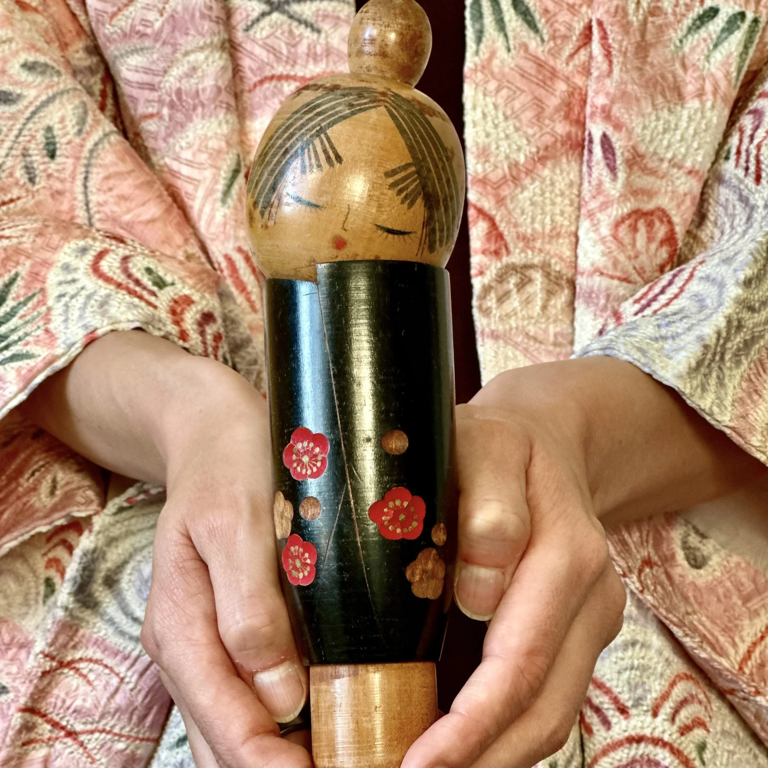 sato-suigai-kokeshi-black-lacquer-plum-blossom-held.jpg