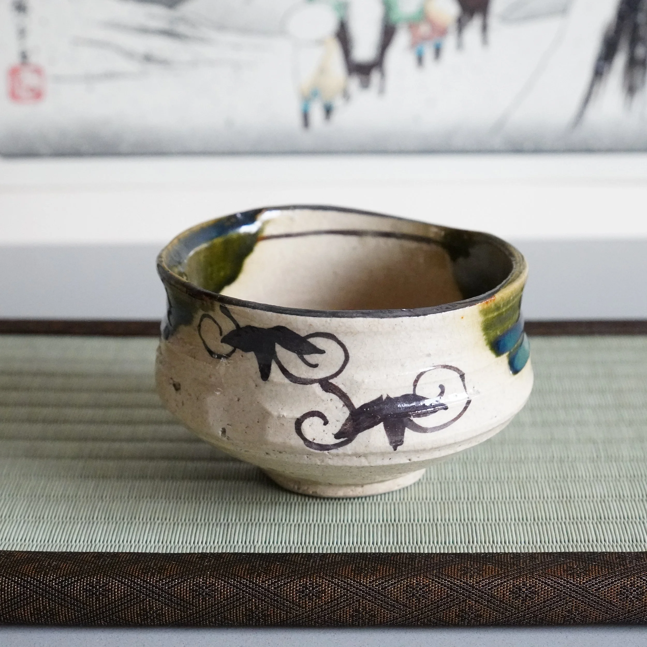 Ao-Oribe chawan side view iron brushwork karakusa vine scroll arabesque on cream Mino ware stoneware copper green glaze band Showa period Japanese matcha bowl