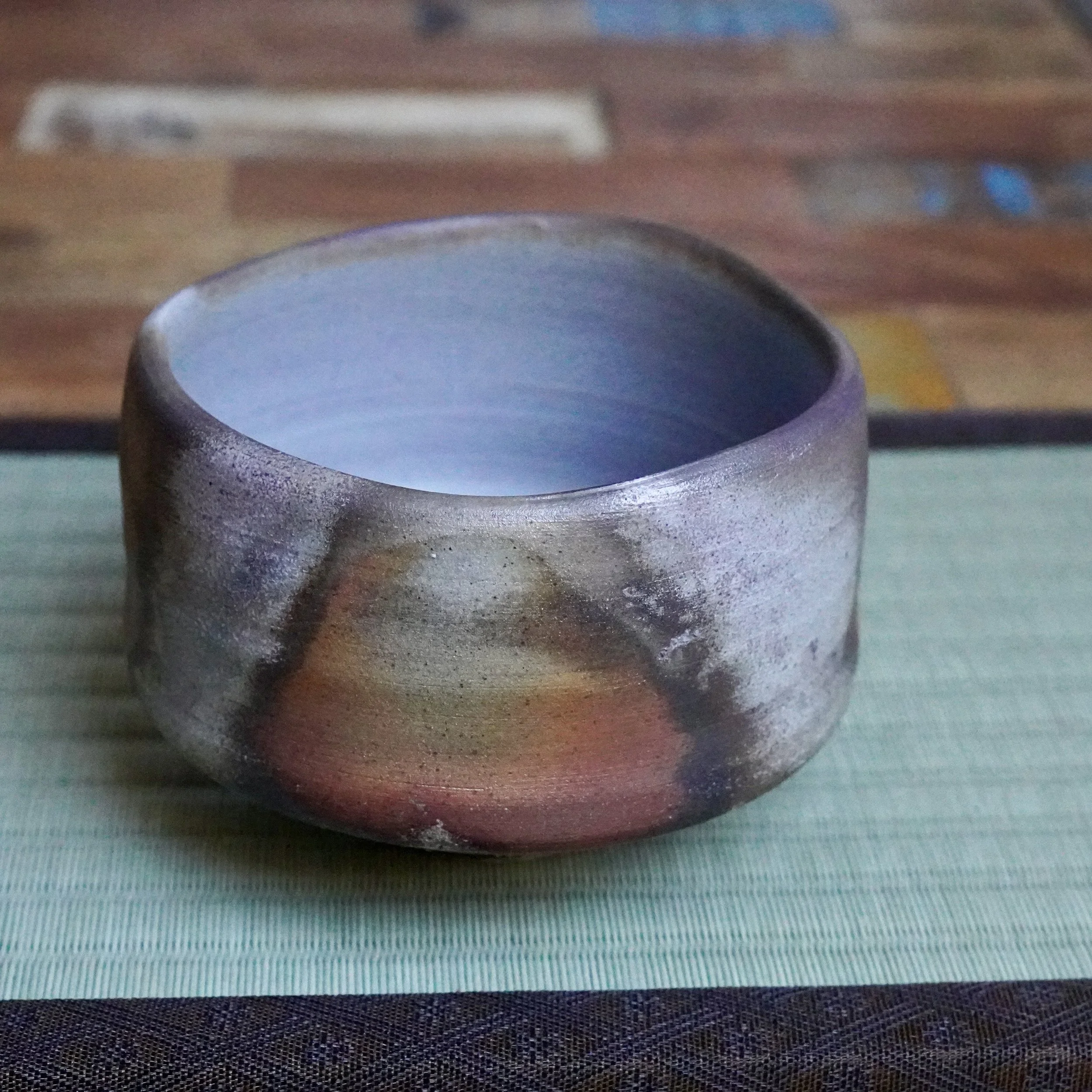 Inomata Masaaki Sangiri Bizen chawan with deep rust, burnt orange, and ash grey exterior, a silver-dusted rim, and a soft blue-grey interior.