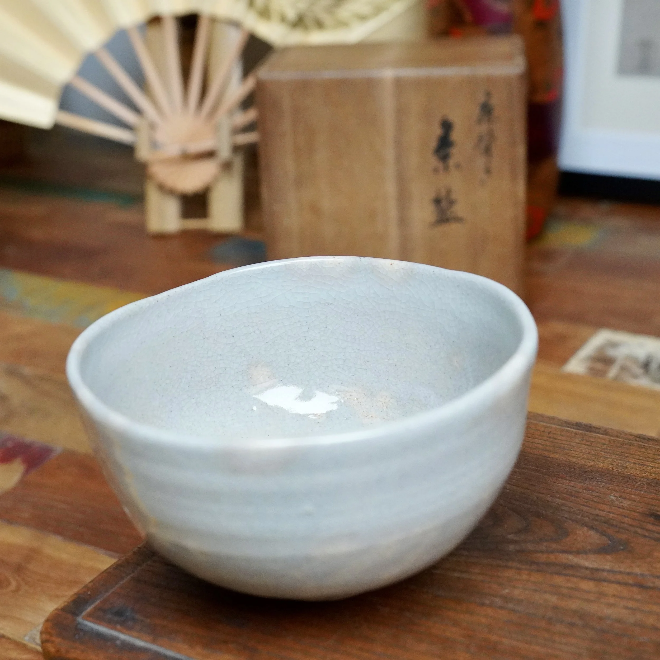 Nagasawa Minoru Izushi ware chawan, soft grey-blue crackled glaze with pink blush inside, irregular shape and pressed rim.