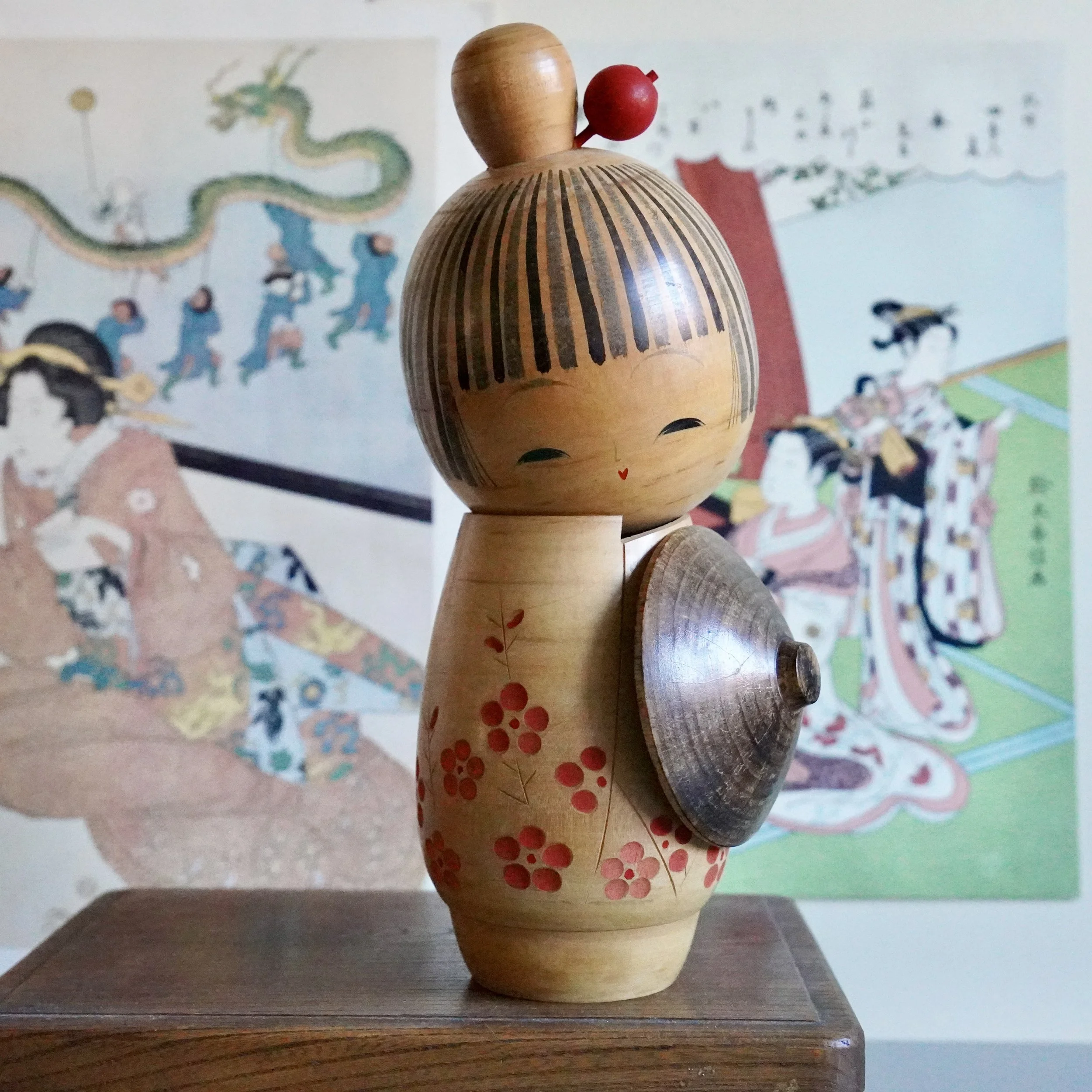 Sōsaku kokeshi by Sato Suigai, full figure with carved plum blossom kimono and wooden kasa hat