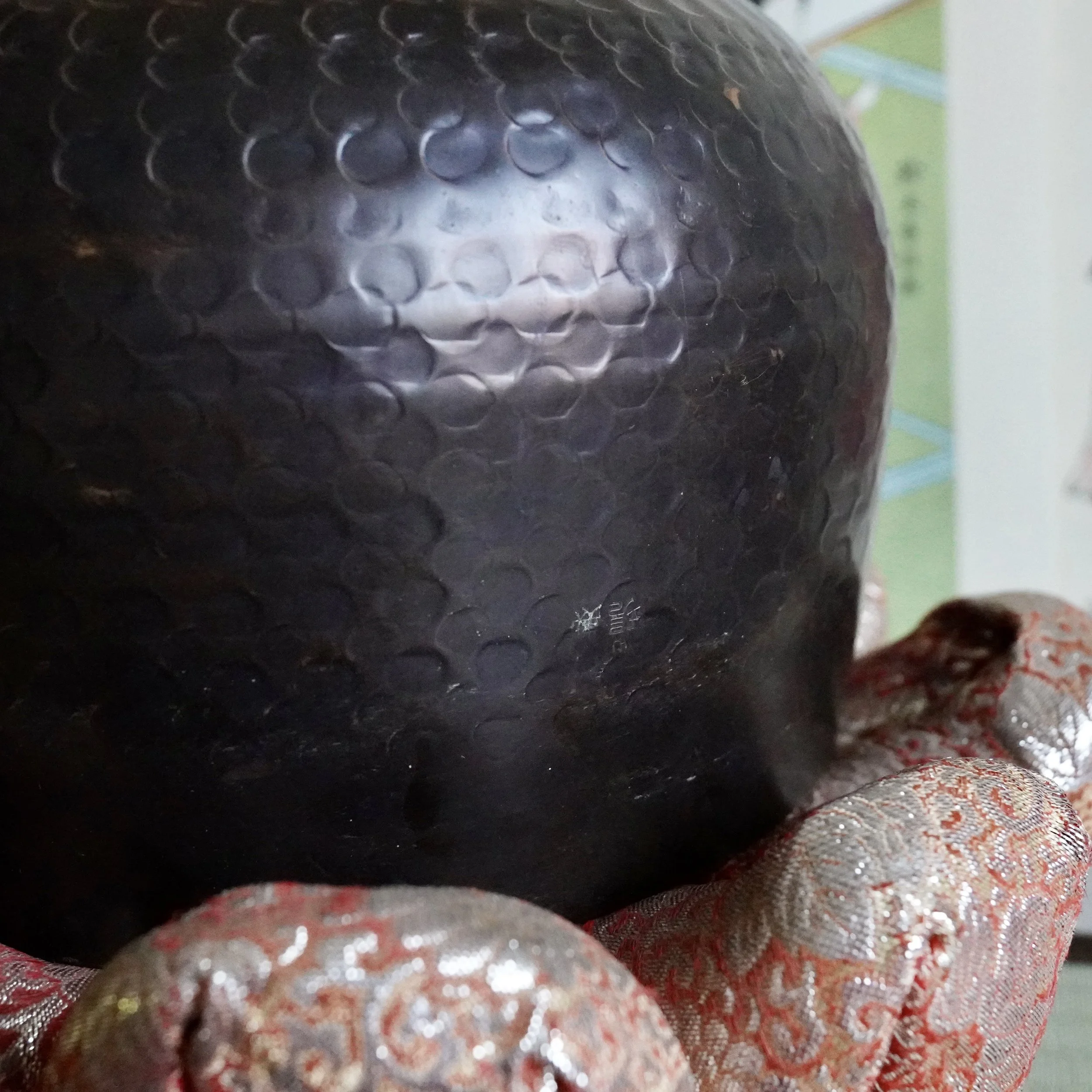 Close-up of hand-hammered dimple pattern on signed Tsutsumi orin exterior, Japanese bronze singing bowl