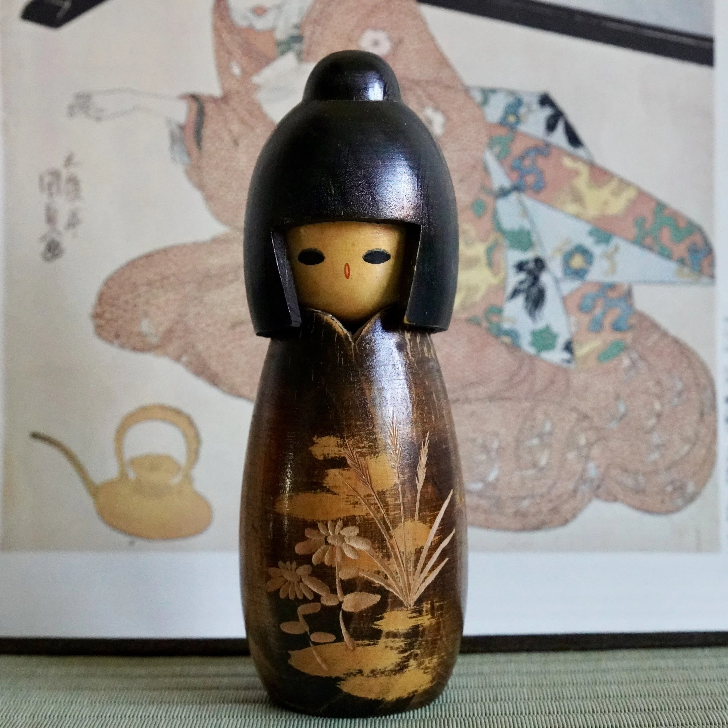Dark lacquered kokeshi with carved relief decoration, Takeda Masashi