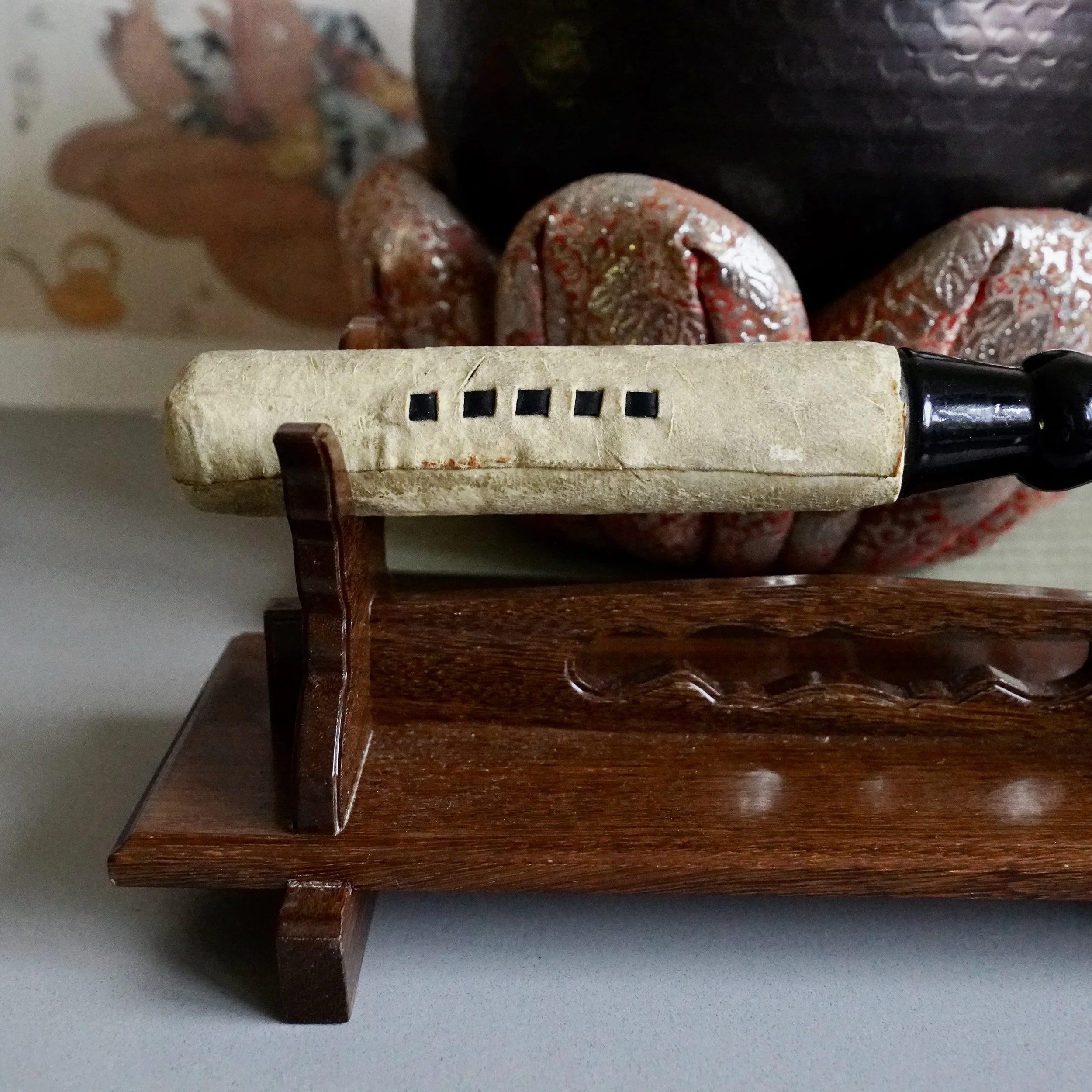 Striker resting on wooden stand beside large signed Tsutsumi orin, Japanese bronze singing bowl