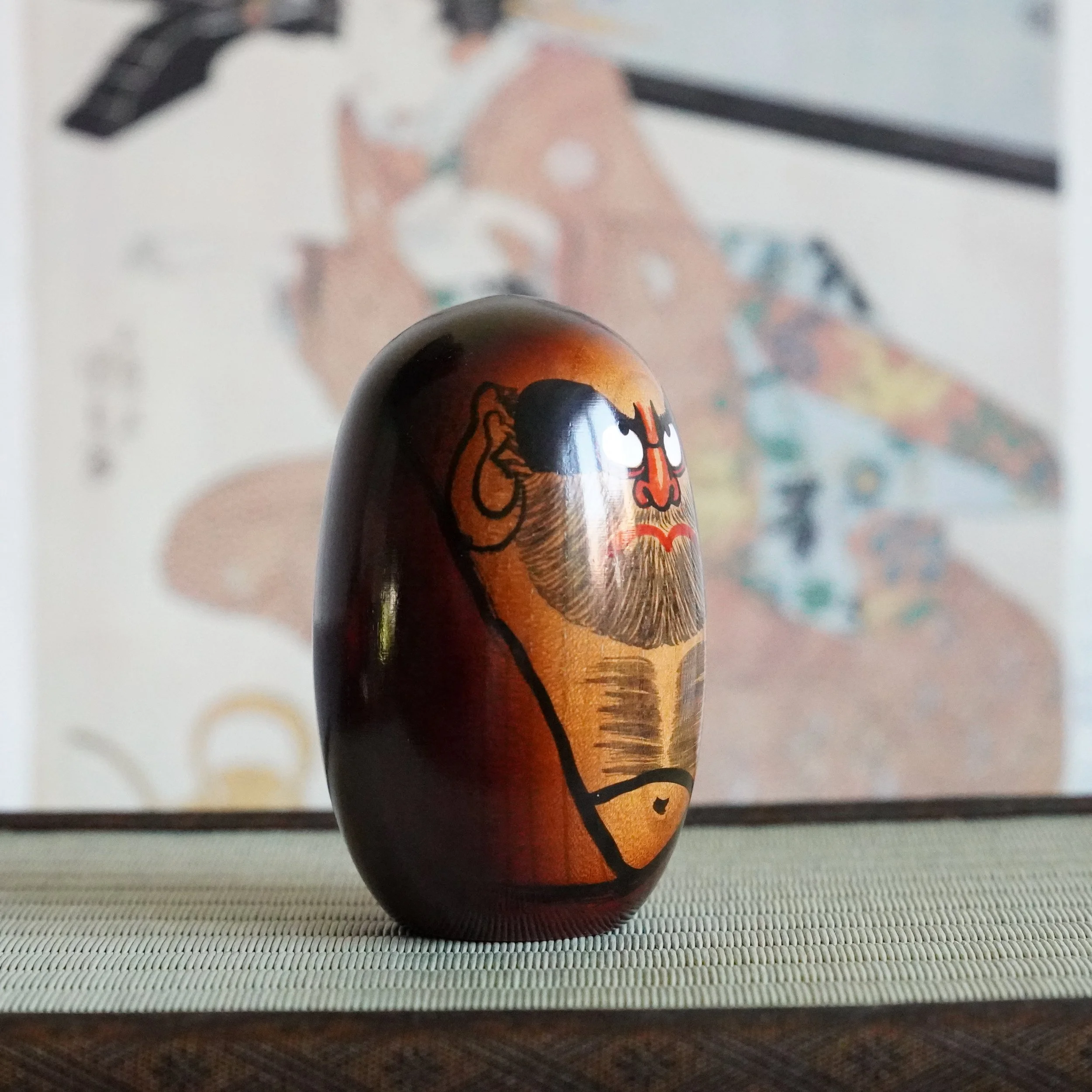 Side profile of a keyaki wood Daruma Daishi by Seifu Gono, hand painted face, vintage Japanese mingei craft