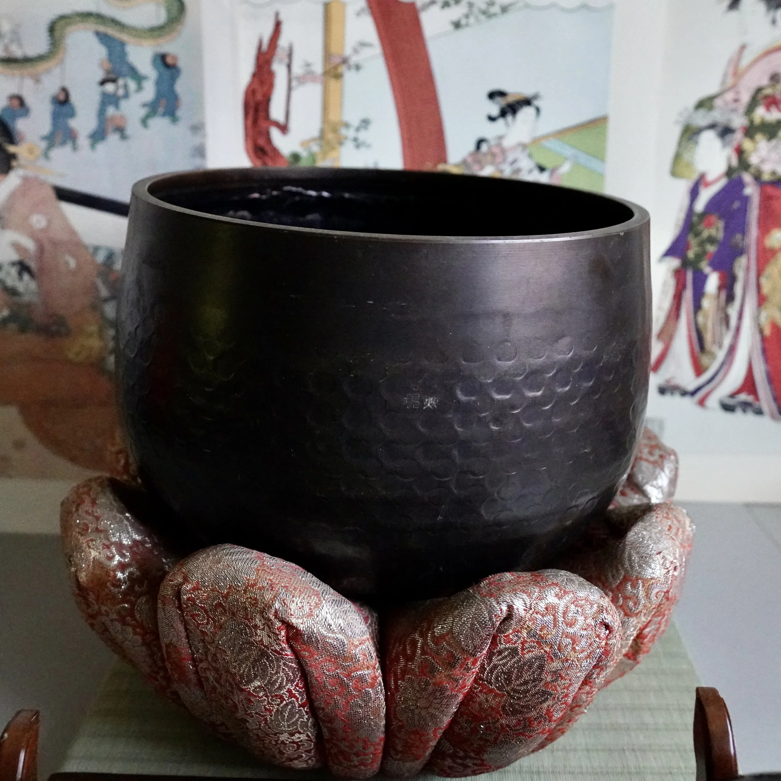 Large signed Tsutsumi orin, hand-hammered Japanese bronze singing bowl, on red and gold brocade cushion