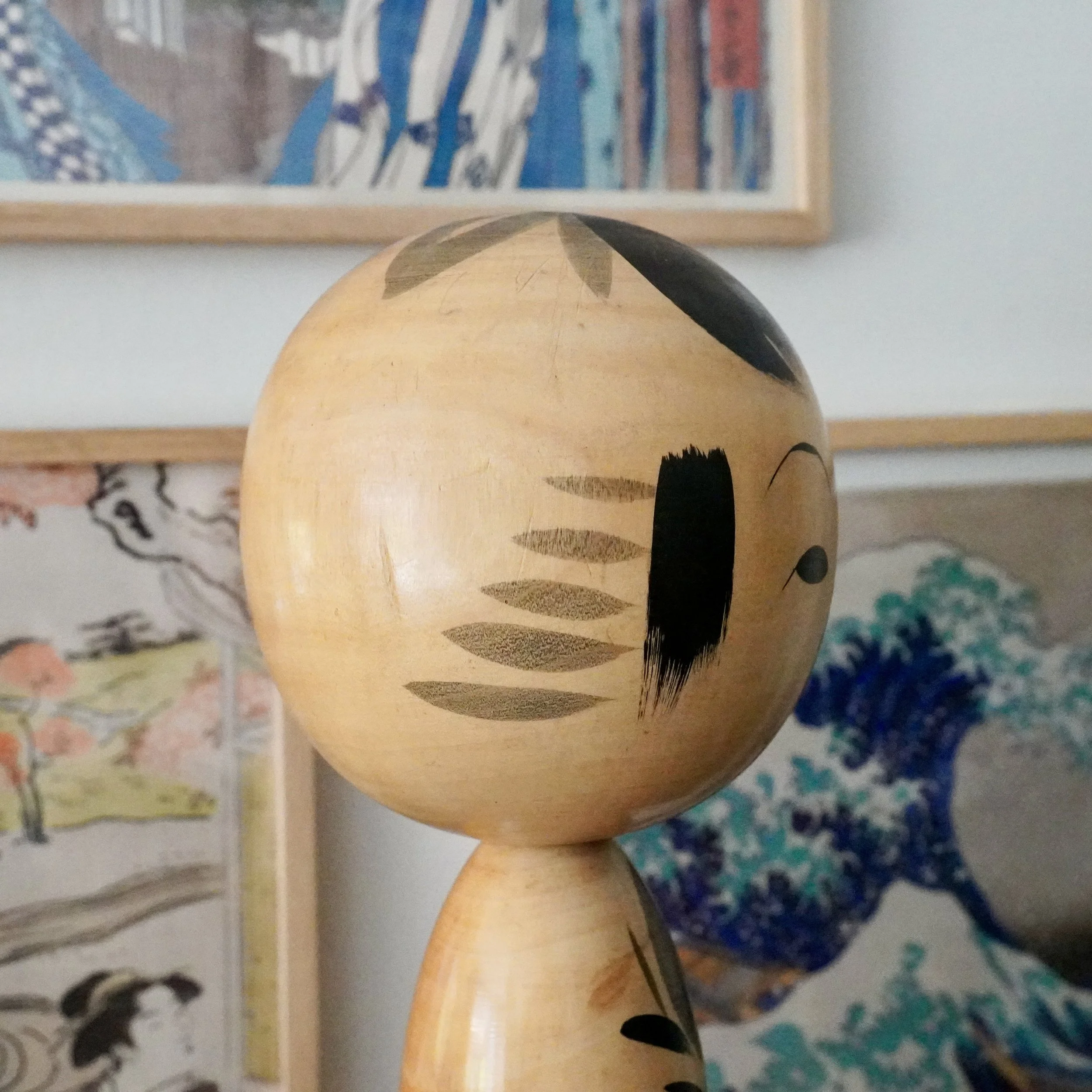 Japanese kokeshi doll head close-up, hand-painted face, warm cream wood tone, signed tetsuen