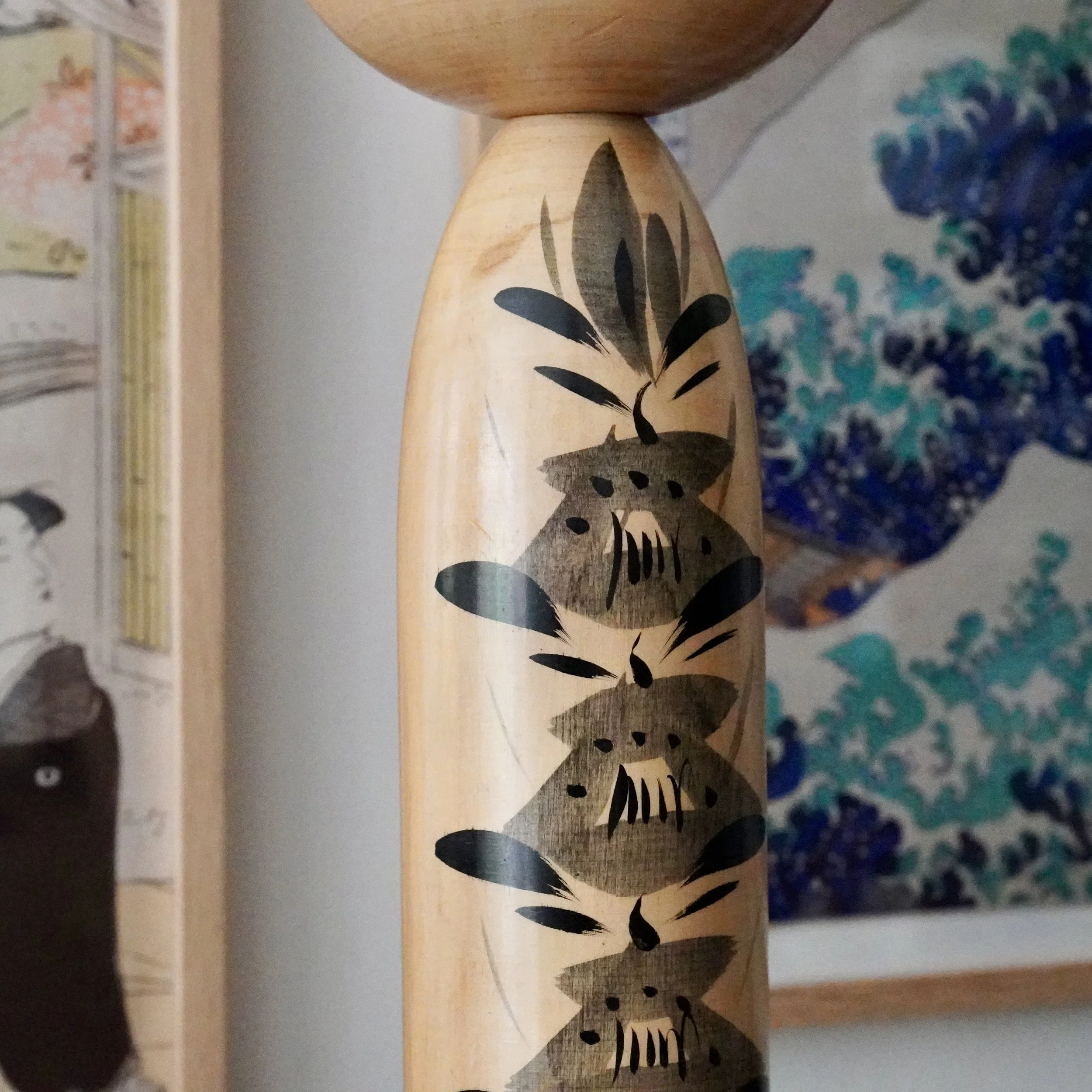 Kokeshi doll body detail, hand-painted black and grey flower motif, Tetsuen style Japanese folk art