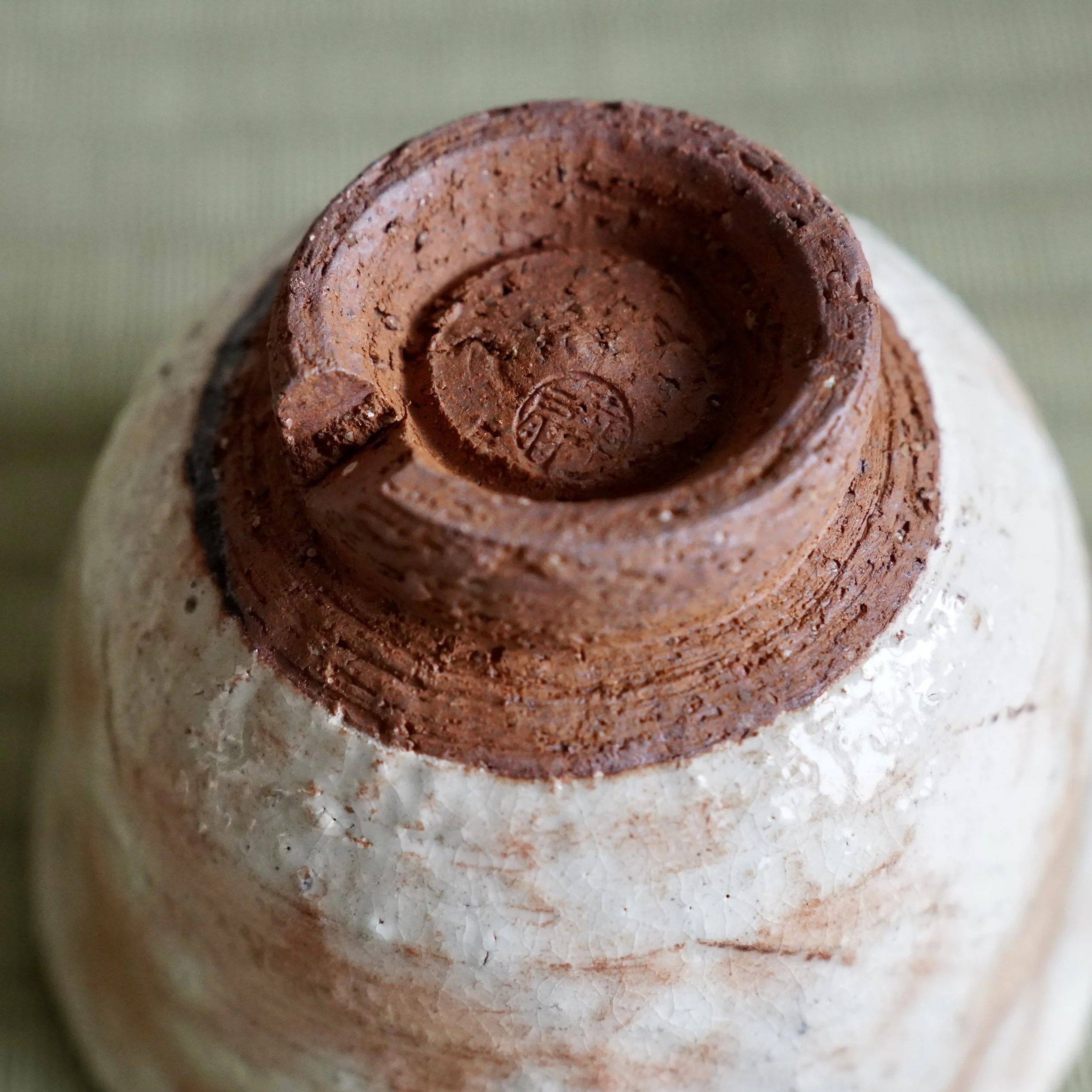 Base of Hagi-yaki yunomi by Taizan kiln 泰山窯, impressed kiln stamp on unglazed terracotta kodai foot, rough Hagi clay texture, Japan Shōwa period