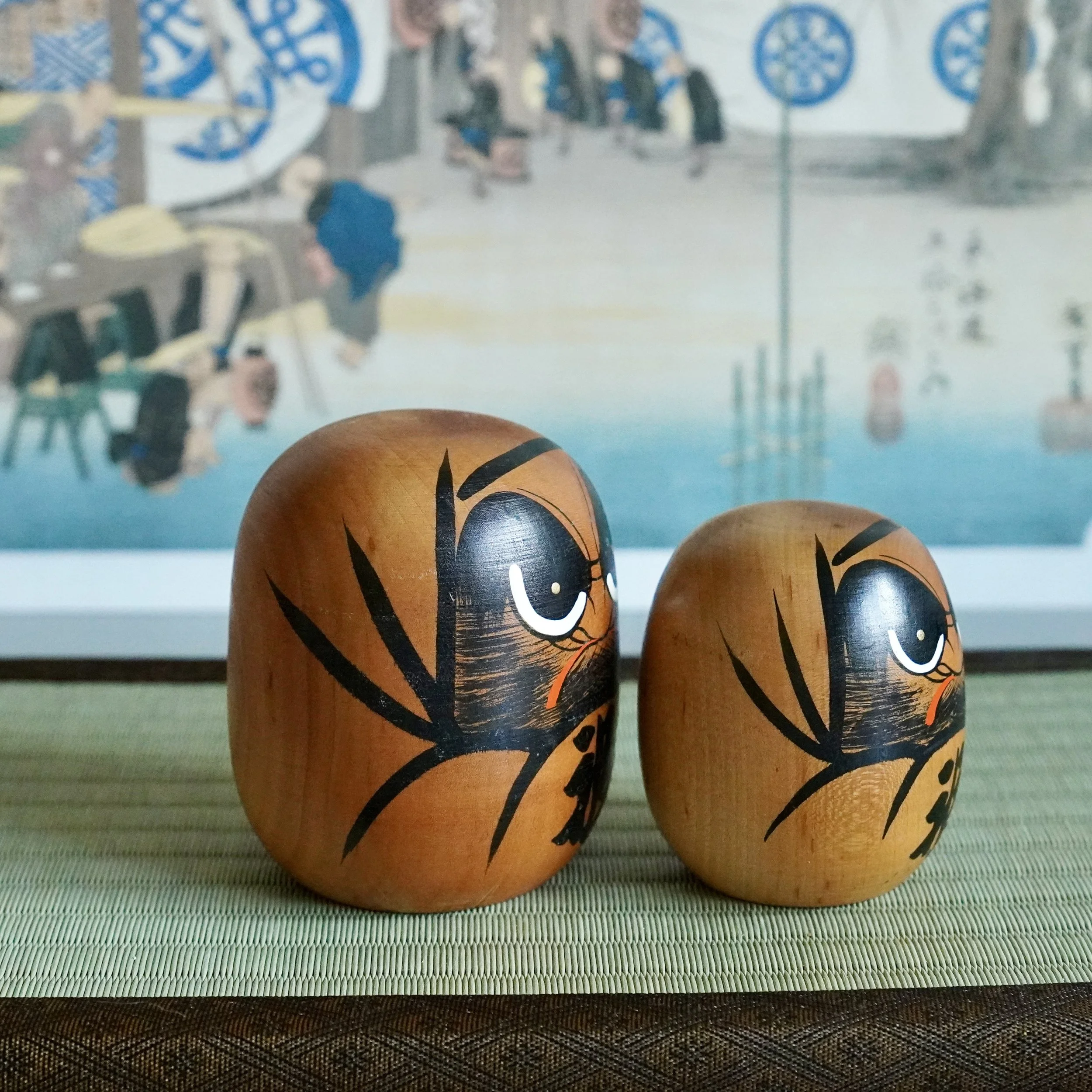 Hand painted wooden daruma pair close up, bamboo brushstroke motif, Japanese folk craft, Showa period.