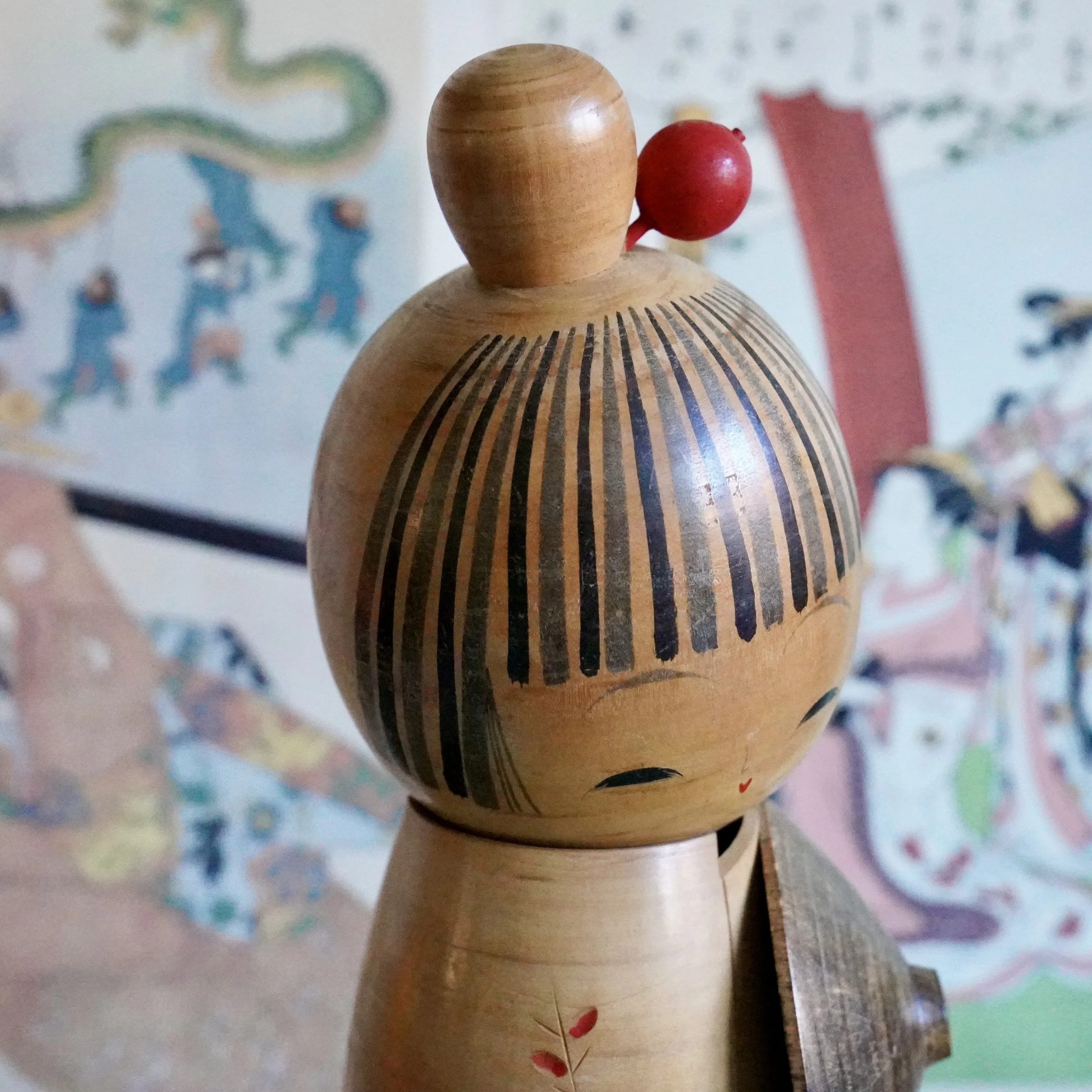 Sato Suigai kokeshi head detail, fine combed striping technique on painted hairstyle