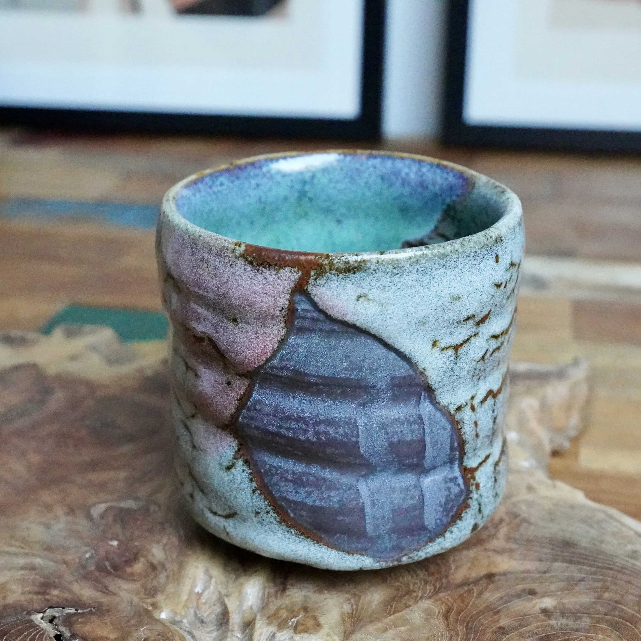 Tall, straight-walled tsutsu chawan with a turquoise interior glaze, a textured exterior of layered grey, pink, and blue, and brown accents.