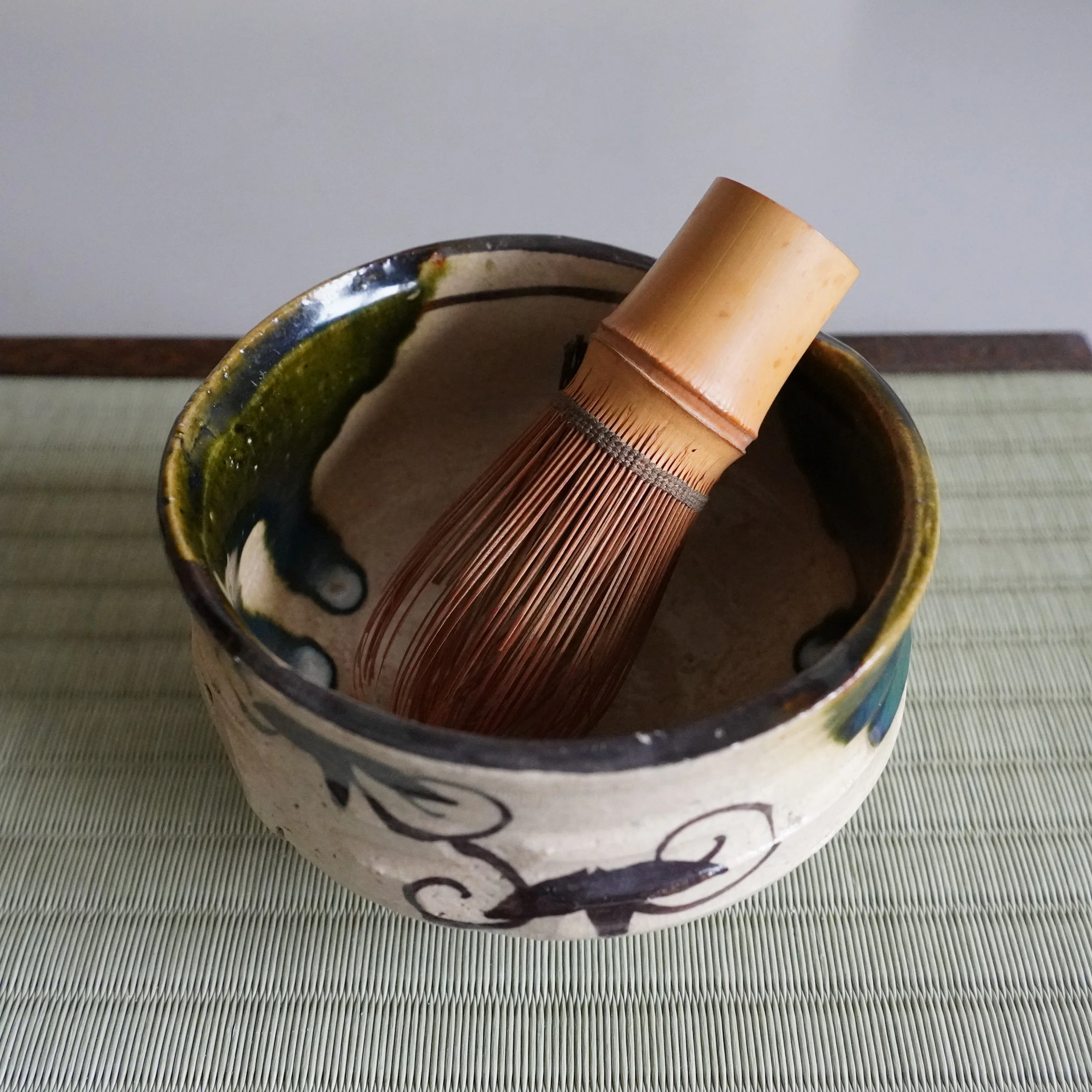 Ao-Oribe chawan with painted figures and vine scrollwork, Mino ware from Shōwa period