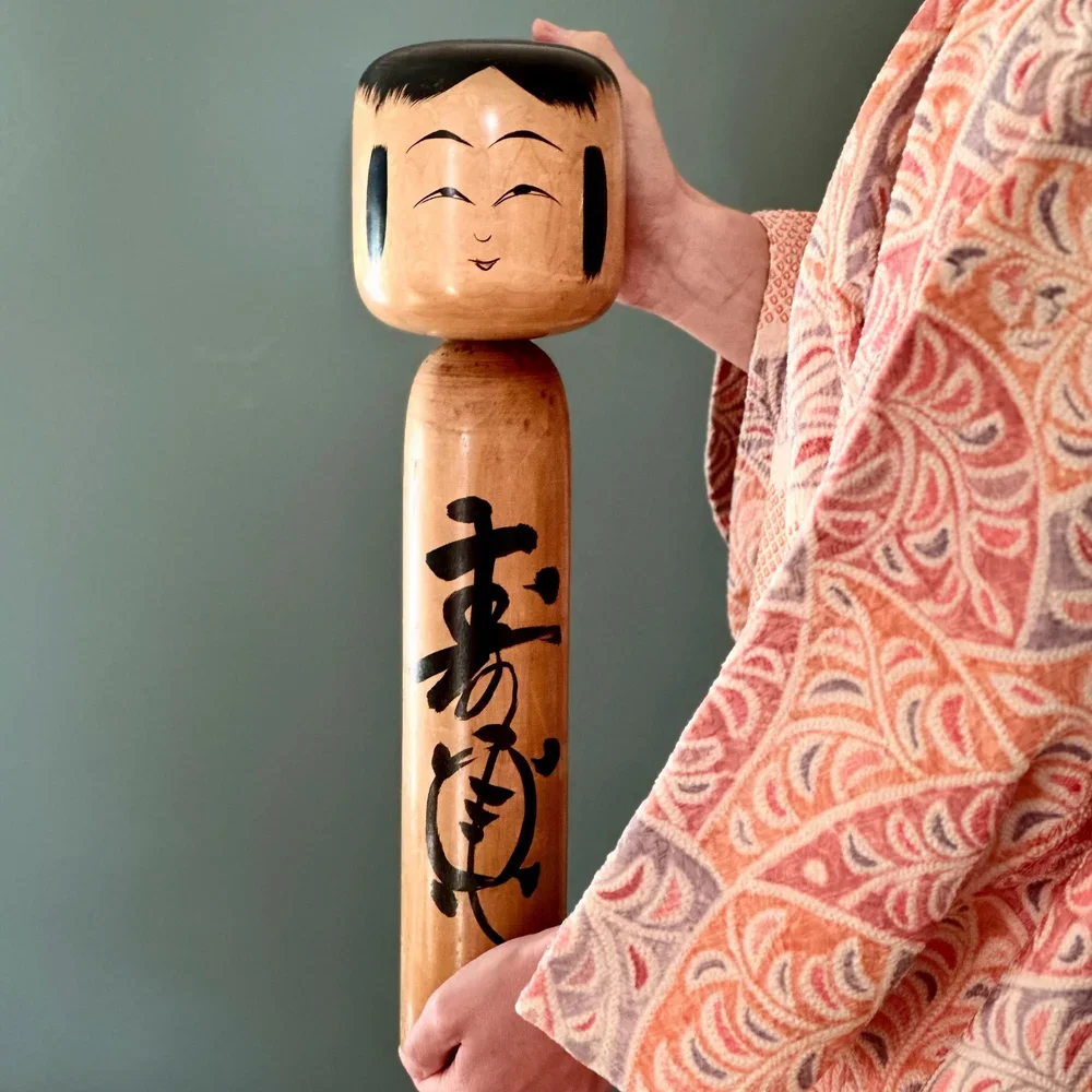 Tōgatta kokeshi Sato Fumio 44cm large traditional style signed held in hands wearing haori shirobi jacket, Shōwa period Japan