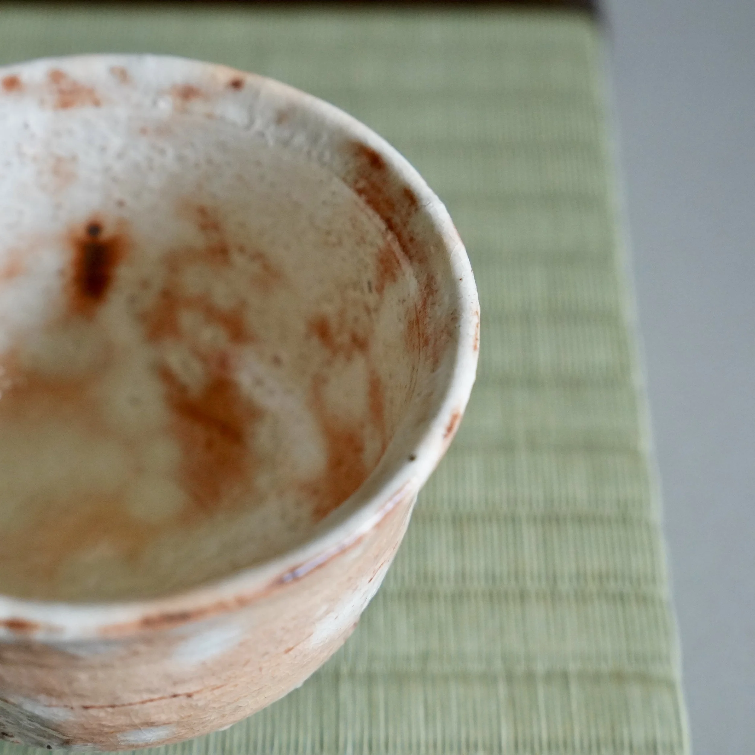 Shira-hagi yunomi by Taizan kiln Hagi-yaki, showing russet clay asserting through thinned white glaze, gohonte-style markings, Shōwa period Japan