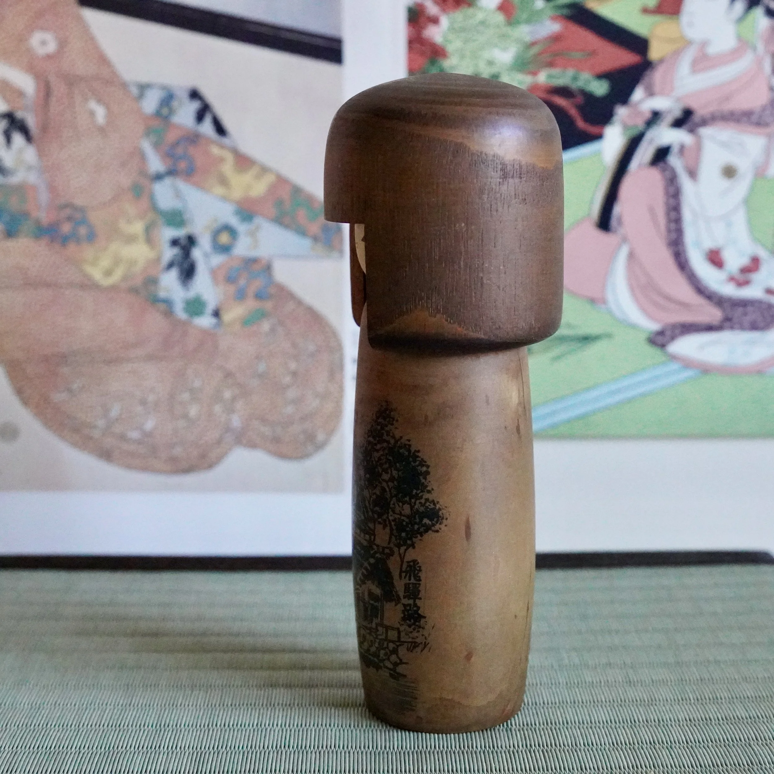 Usaburō kokeshi doll side angle, painted farmhouse scene on lower body