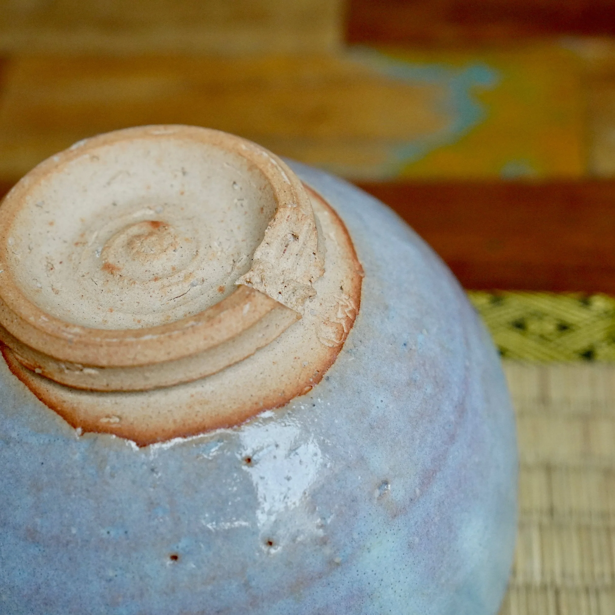 Underside of a ceramic chawan by Moriwaki Fumitada, showing a reddish-brown unglazed warikodai foot and light blue-grey glaze.