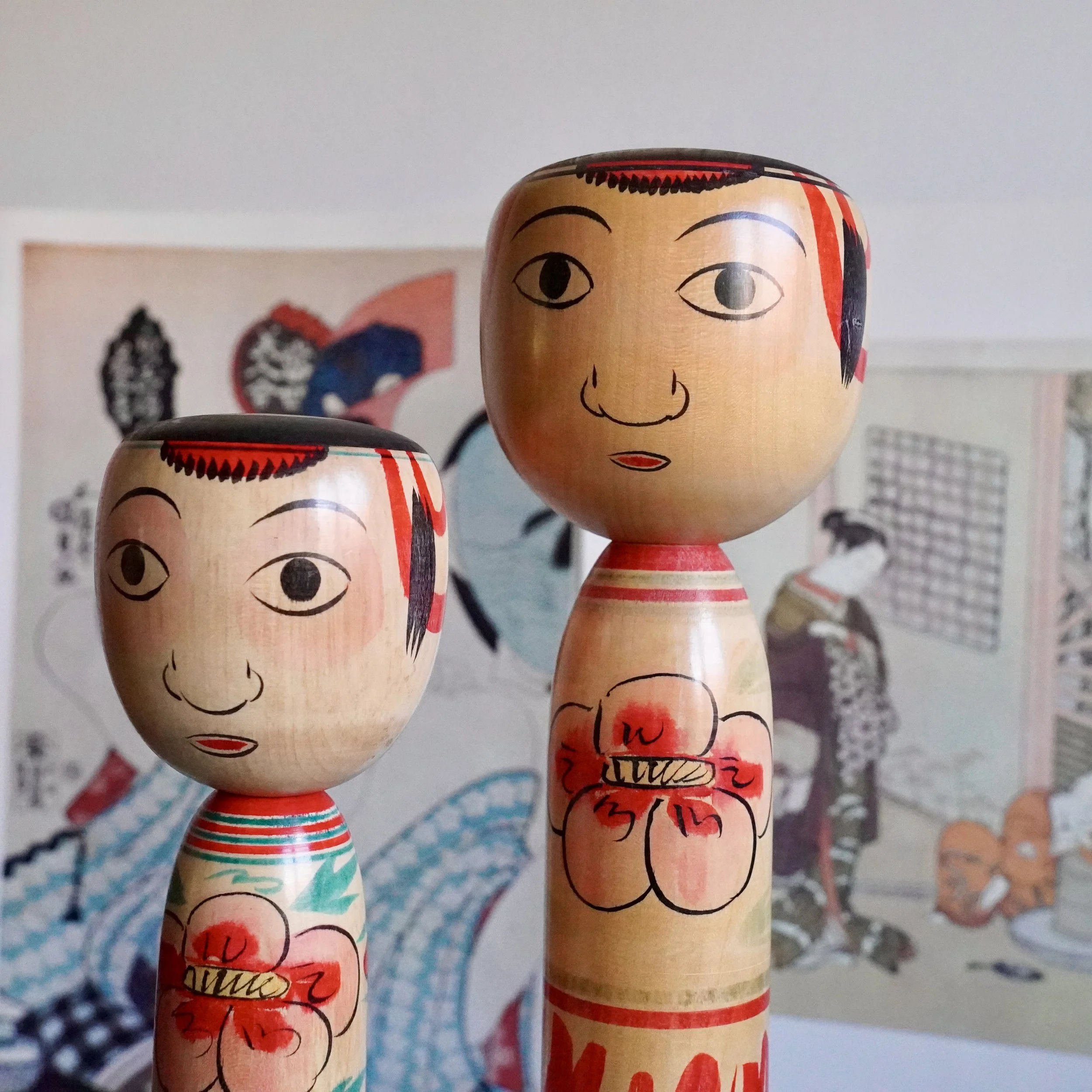 Signed Nakanosawa Takobozu kokeshi pair by Saito Tokuju, tall and short wooden dolls with painted peony bodies