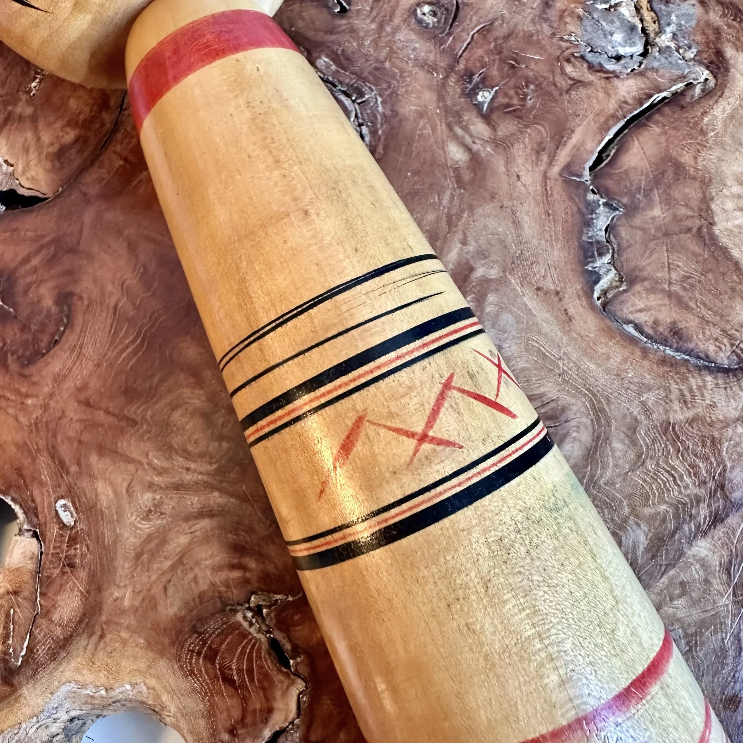 Close-up of zigzag cross banding on an Abe Kazue Tsuchiyu kokeshi, red and black