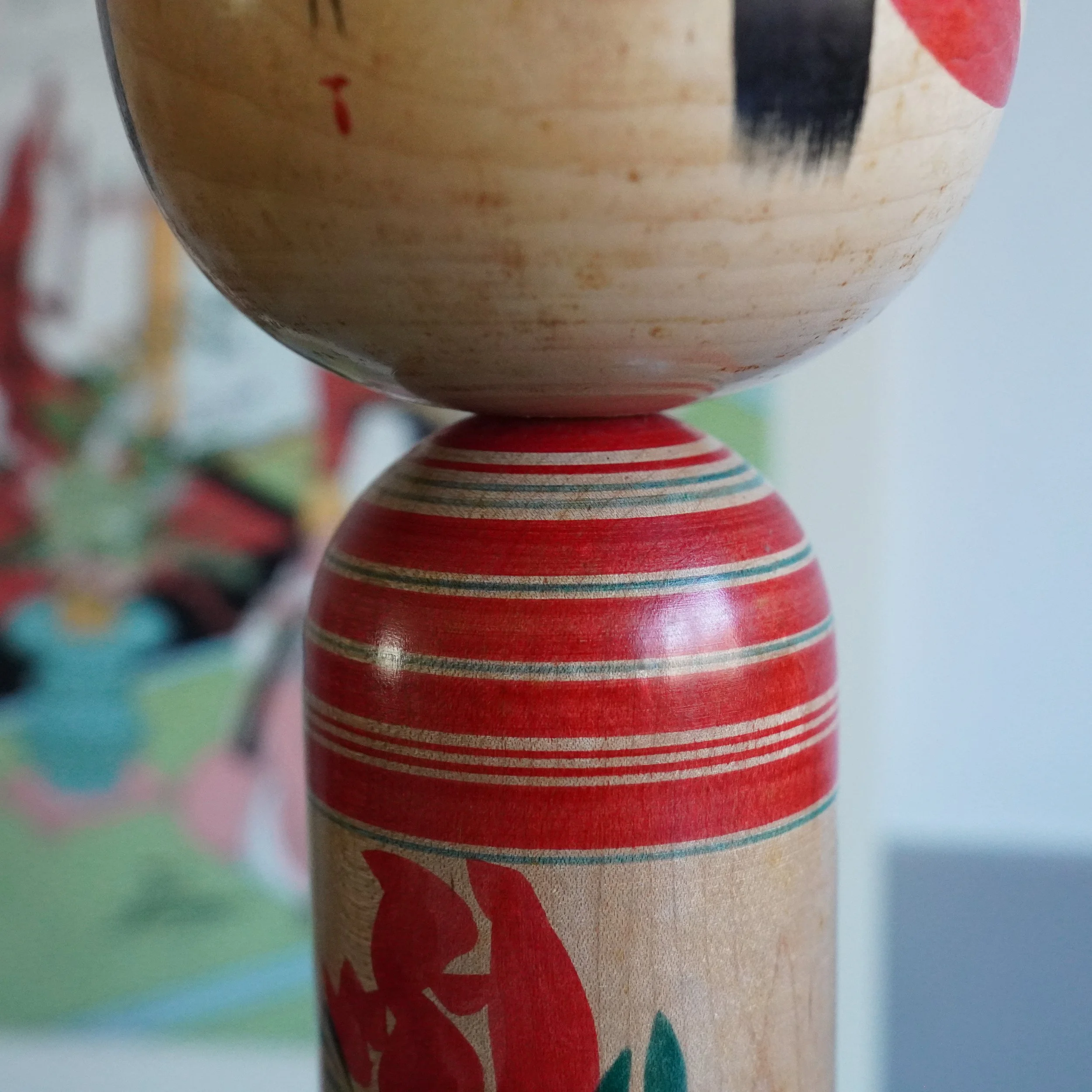Yamagata kokeshi neck and shoulder detail, Takasaki Eiichirō, lathe-turned red and white banding stripes where head meets body, traditional Yamagata-kei construction, Shōwa period